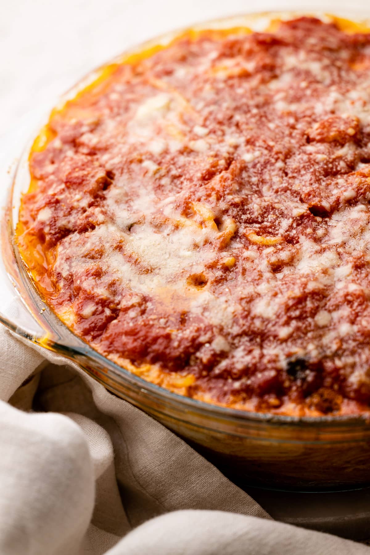 A spaghetti pie with tomato sauce and Parm cheese.