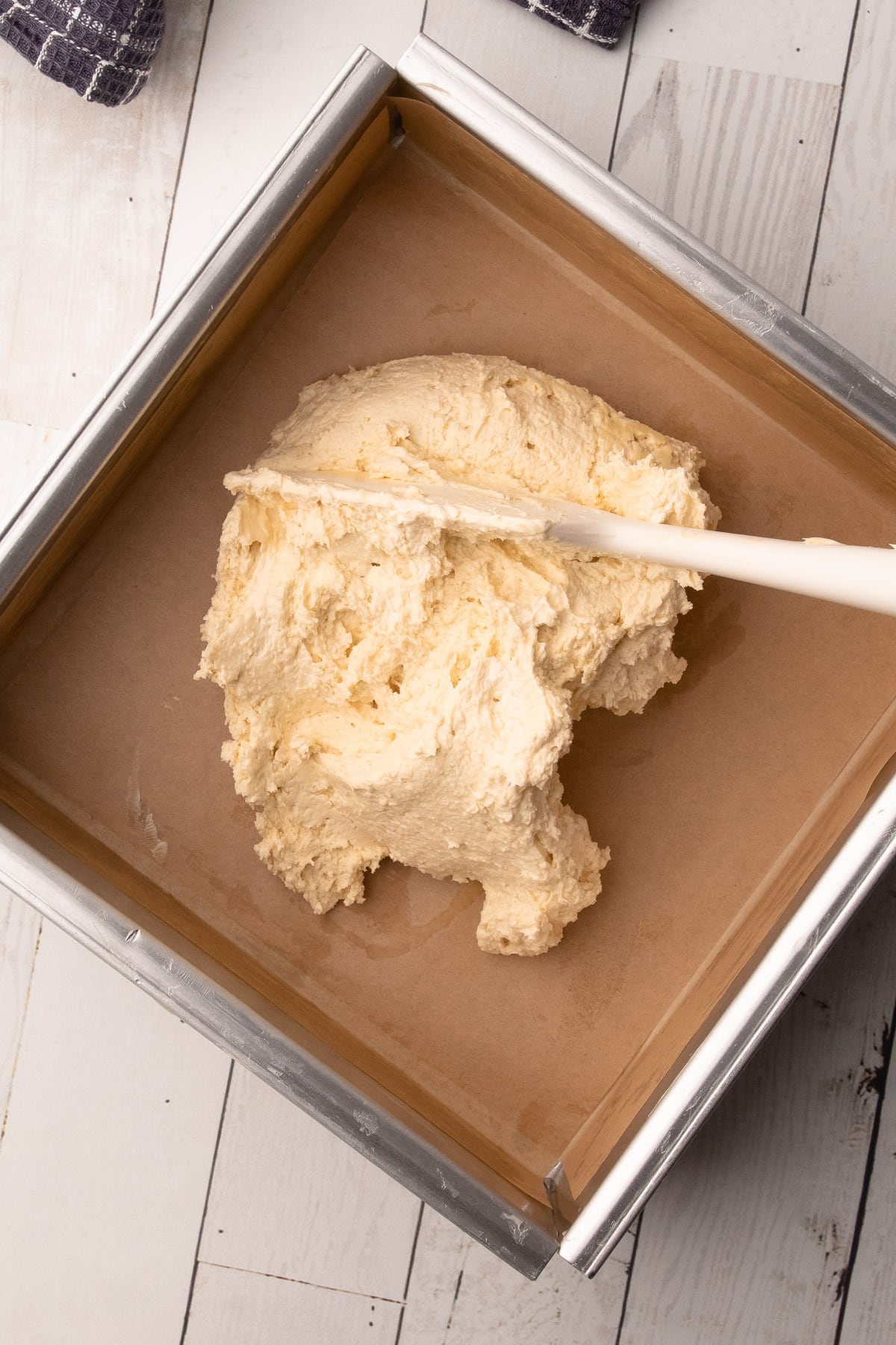 Adding the biscuit dough into the metal pan to make shortbread biscuits.