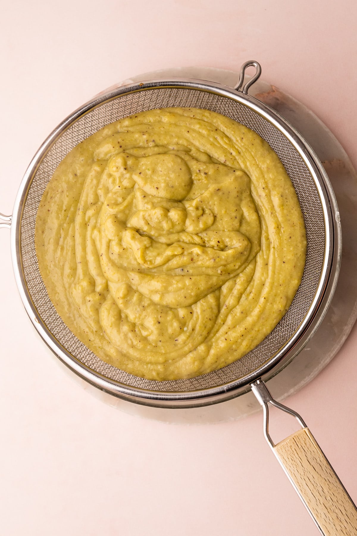 Straining pistachio pudding.