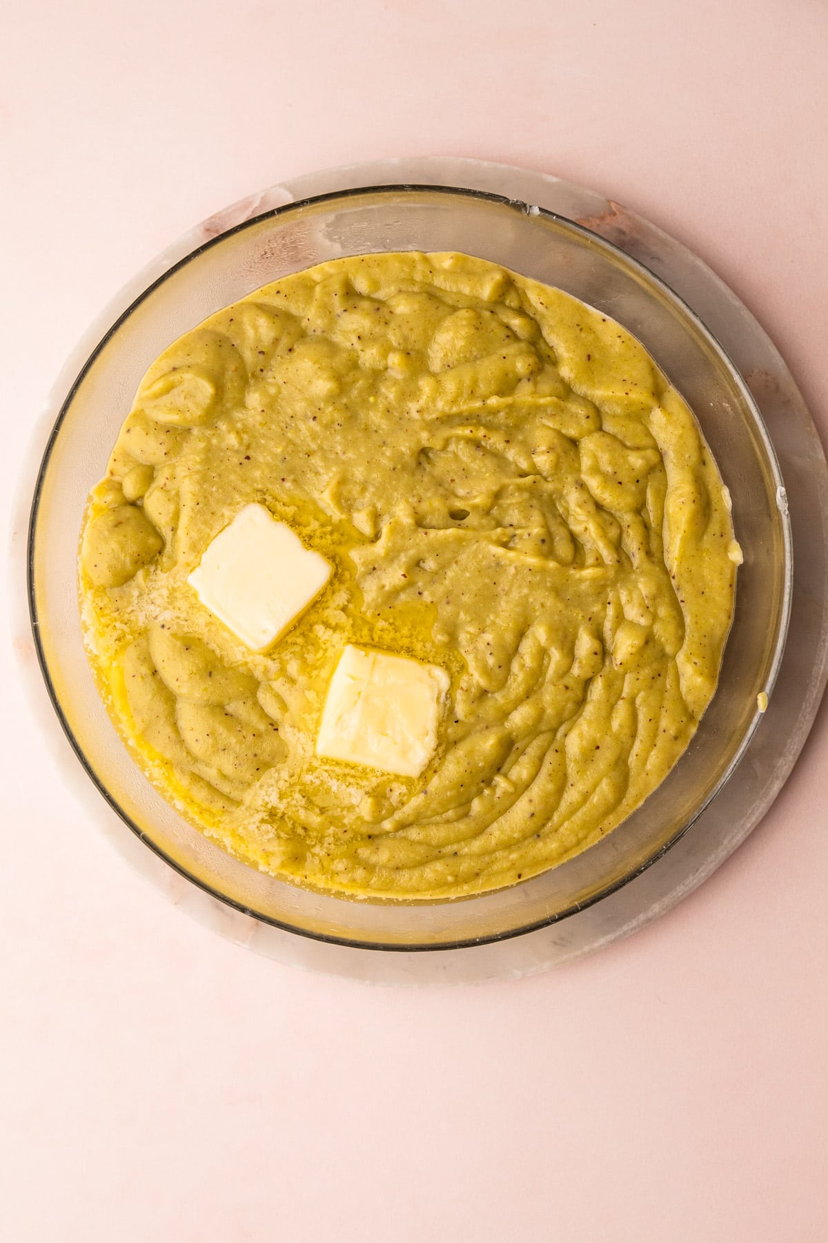 A bowl of homemade pistachio pudding with extract and butter before being completed.