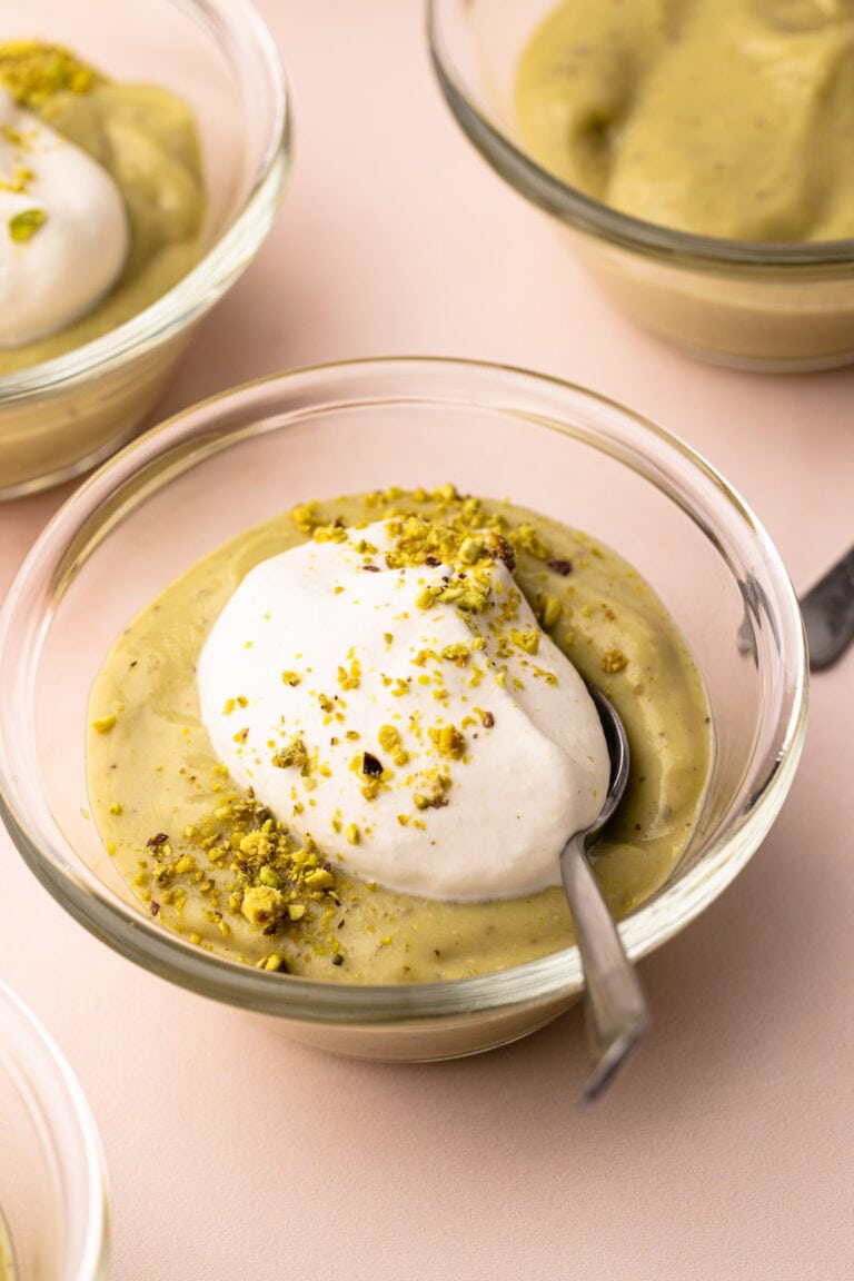 A couple of bowls with homemade pistachio pudding and whipped cream.