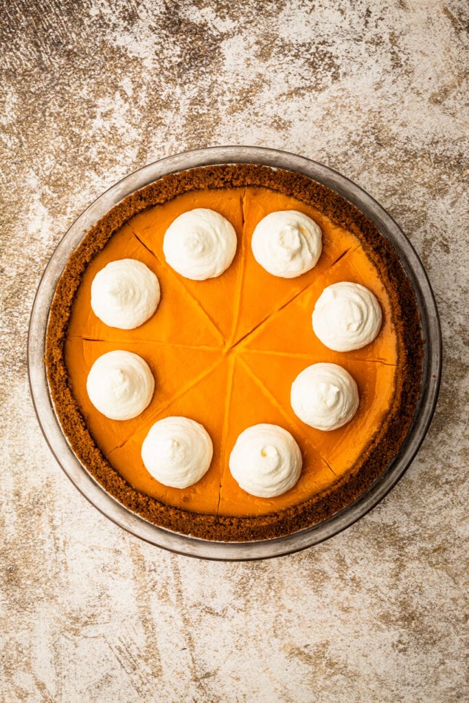 A baked carrot pie with whipped cream.