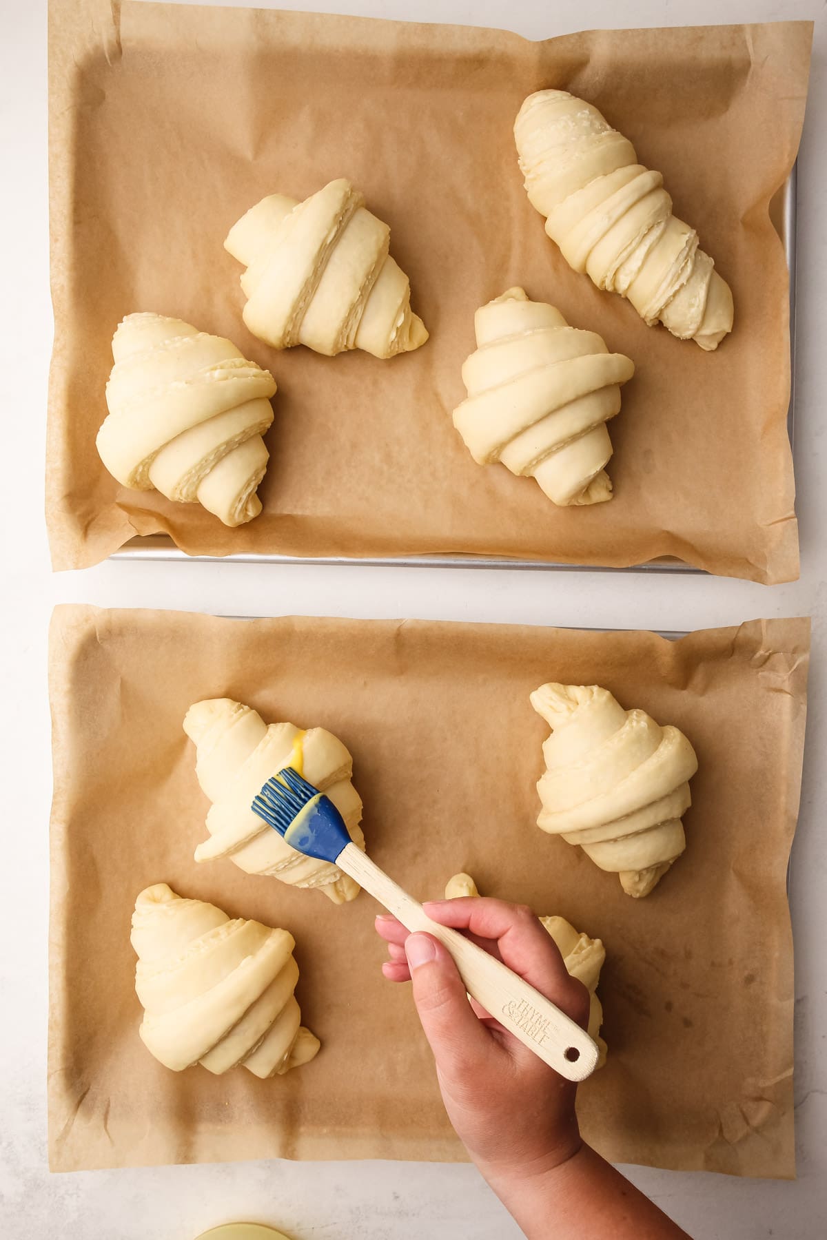 Brushing egg wash on easy croissant dough.