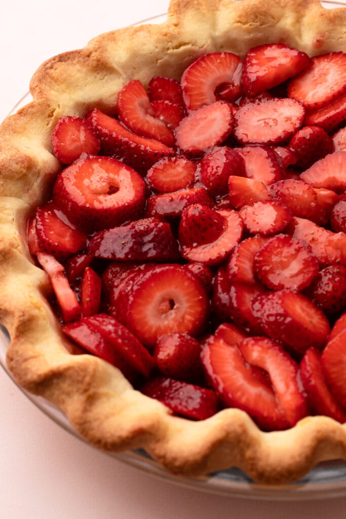 Assembling fresh strawberry pie.