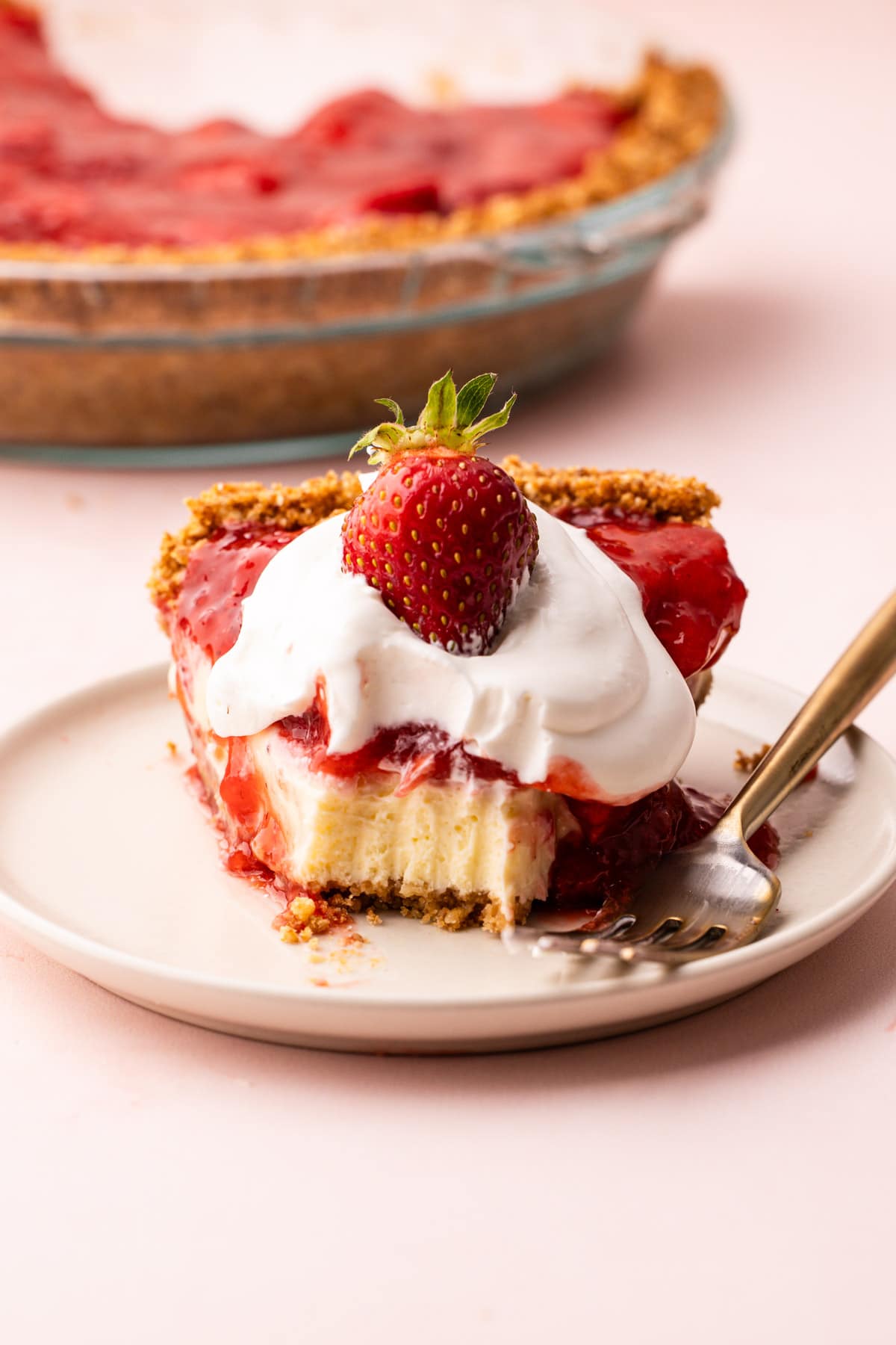 A half eaten slice of strawberry cream cheese pie.