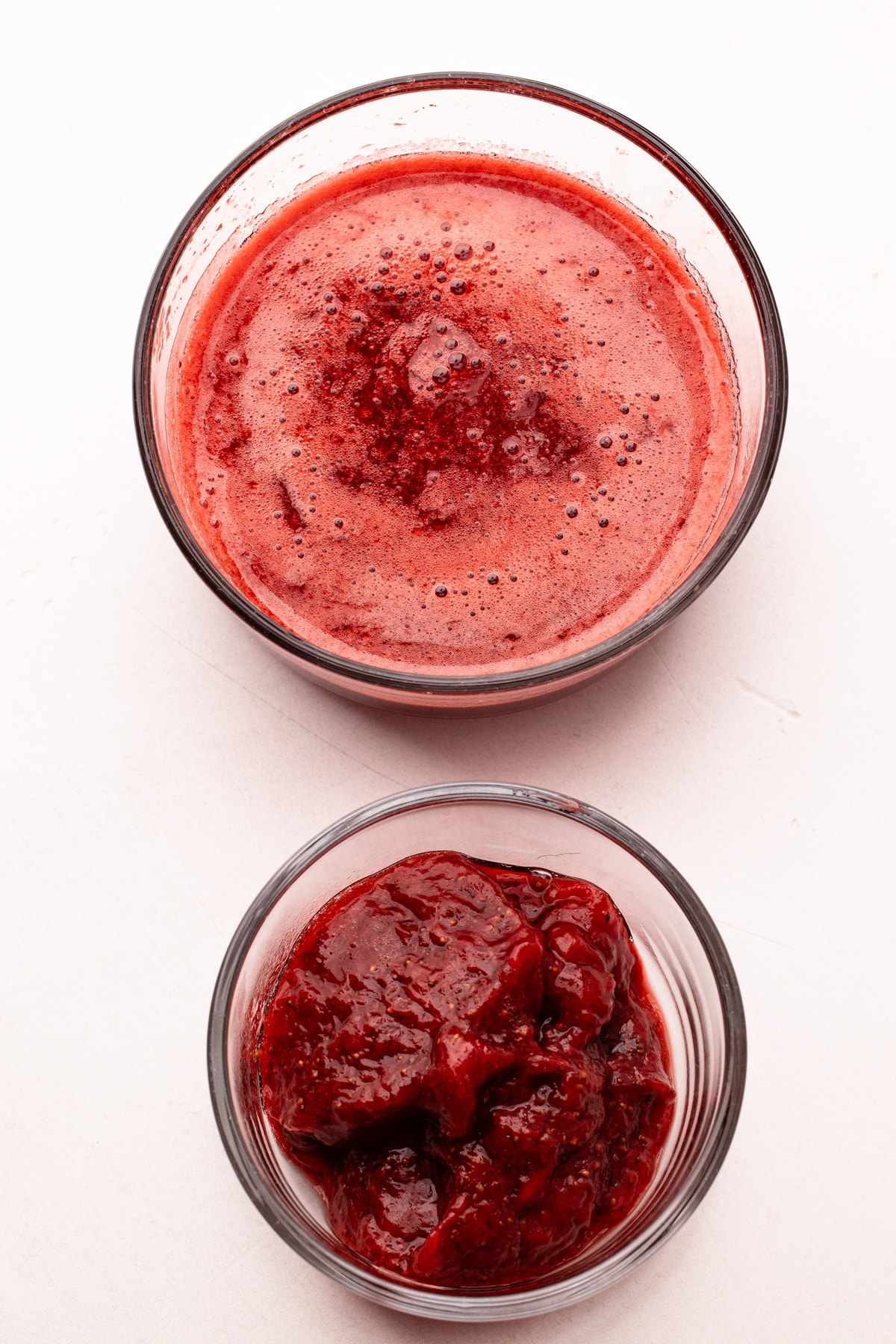 Separated strawberry juice and strawberries for making homemade strawberry ice cream.