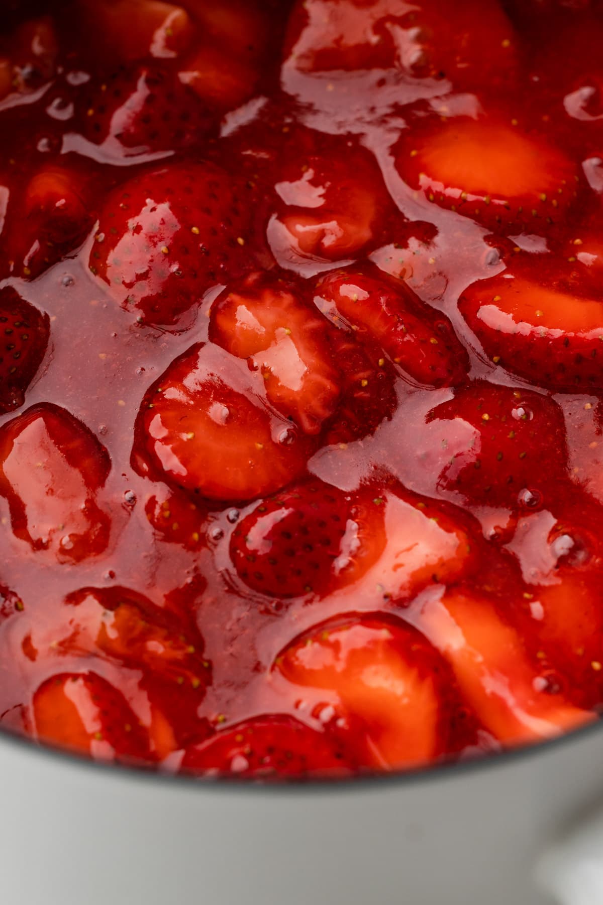 A pot with cooked strawberry pie filling.