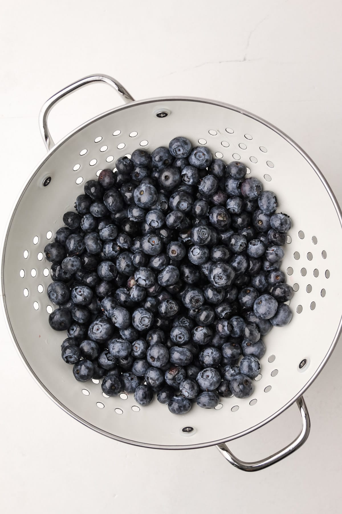 A colander of washed blueberries.