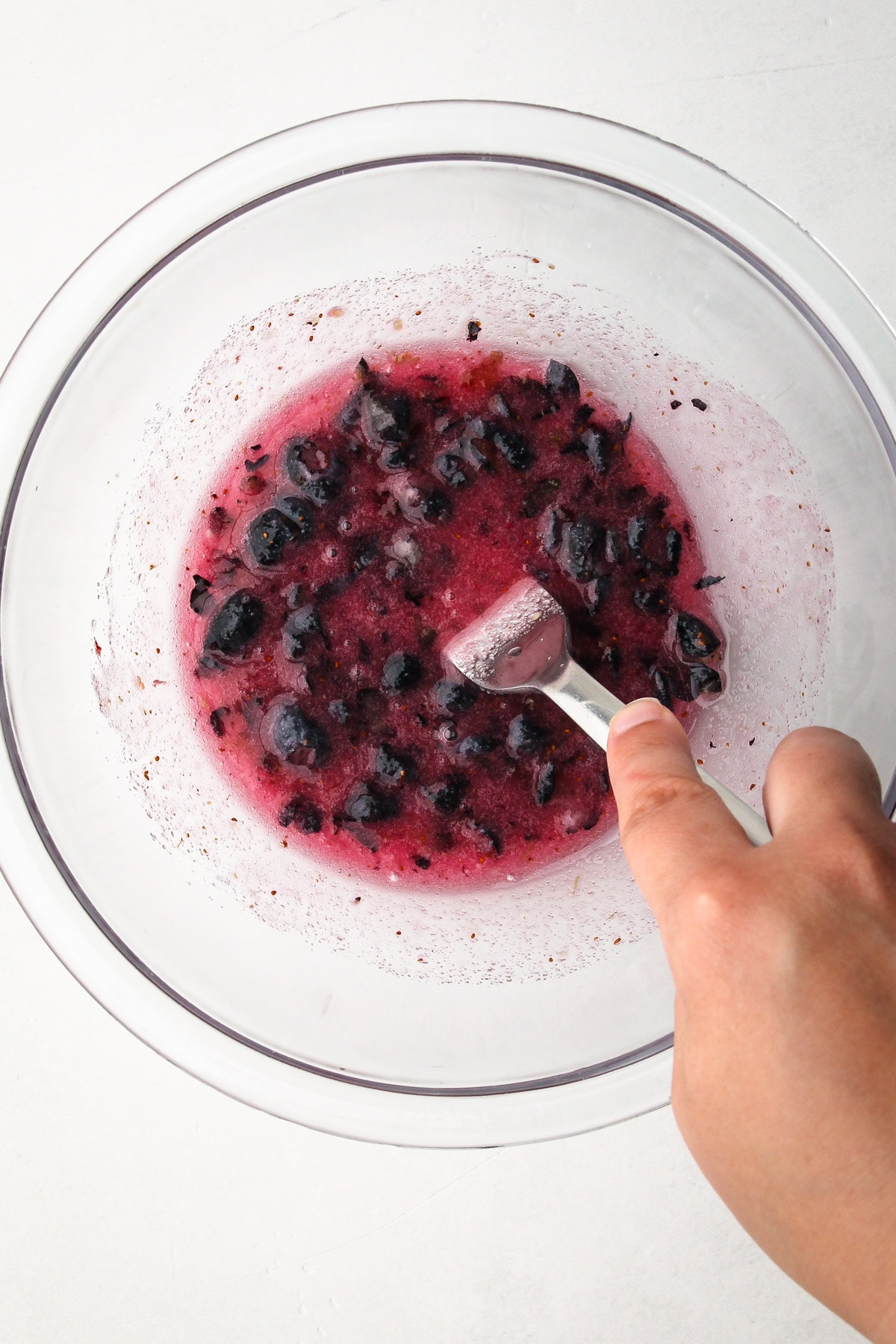 Mashing blueberries for the blueberry pie filling.