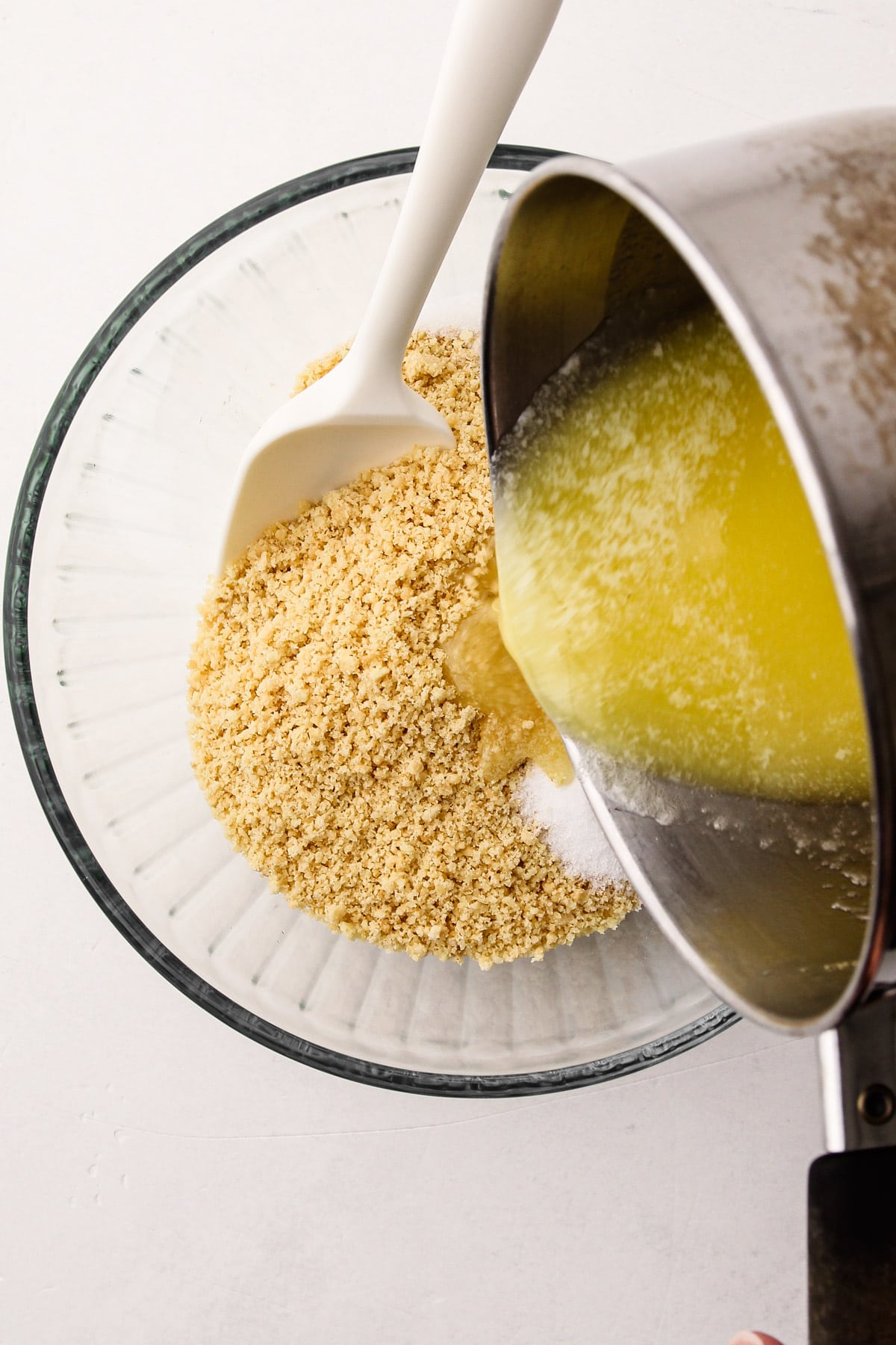 Pouring butter into shortbread pie crust.