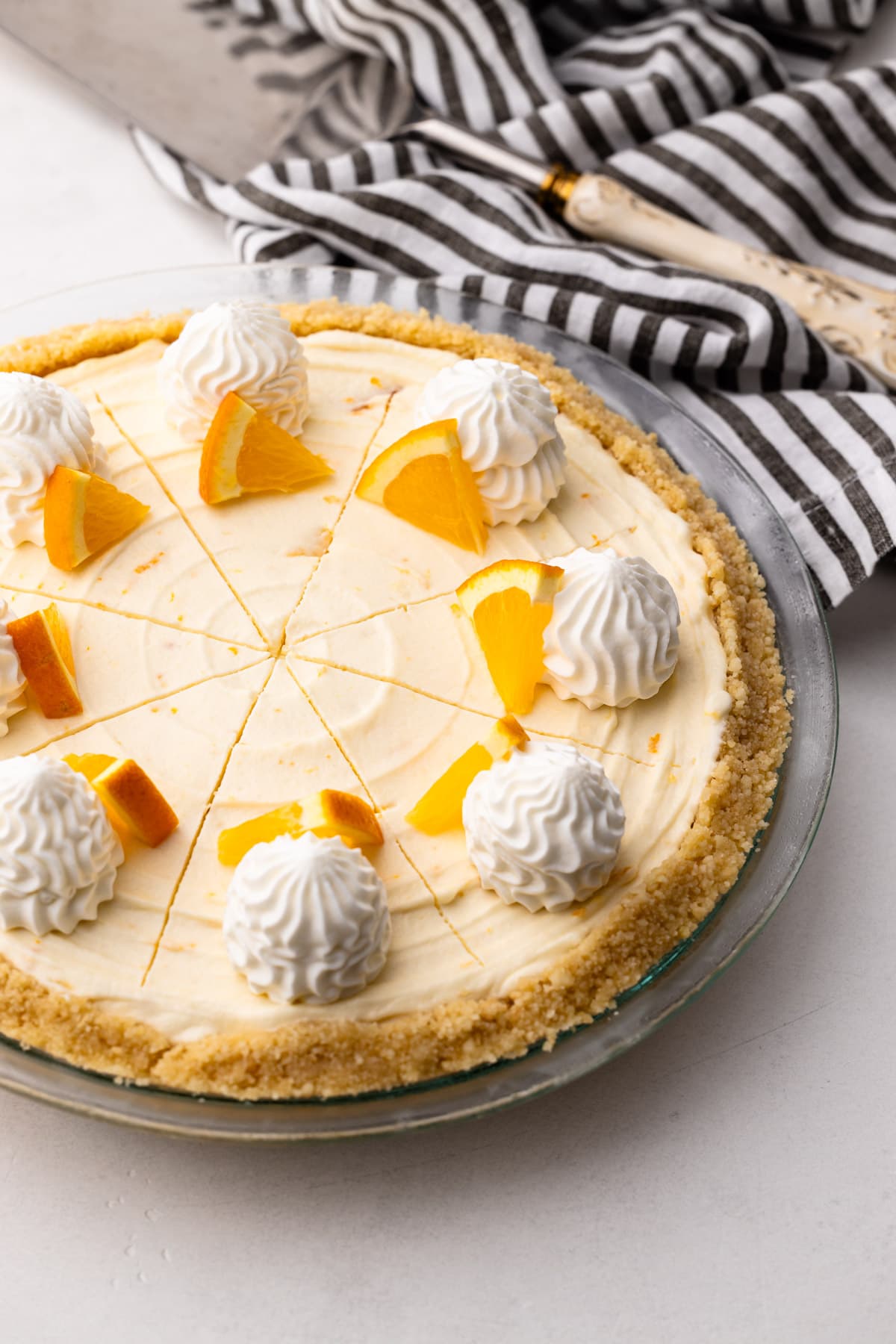 An orange creamsicle pie with slices of fresh orange and whipped cream.