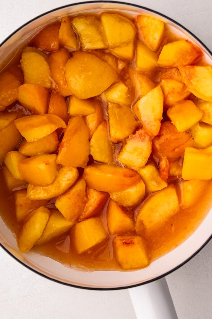 Diced peaches in a pot for peach ice cream.