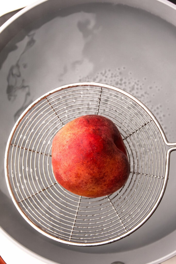 Removing a blanched peach.