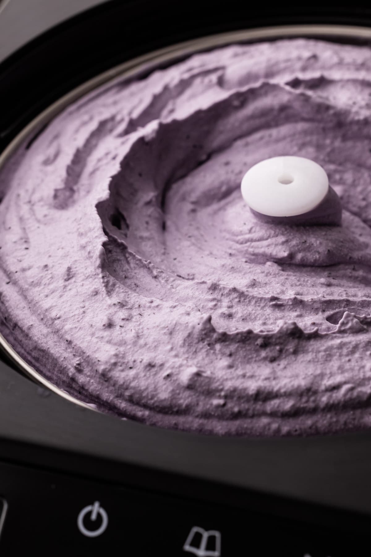 Blueberry ice cream in an ice cream churner.