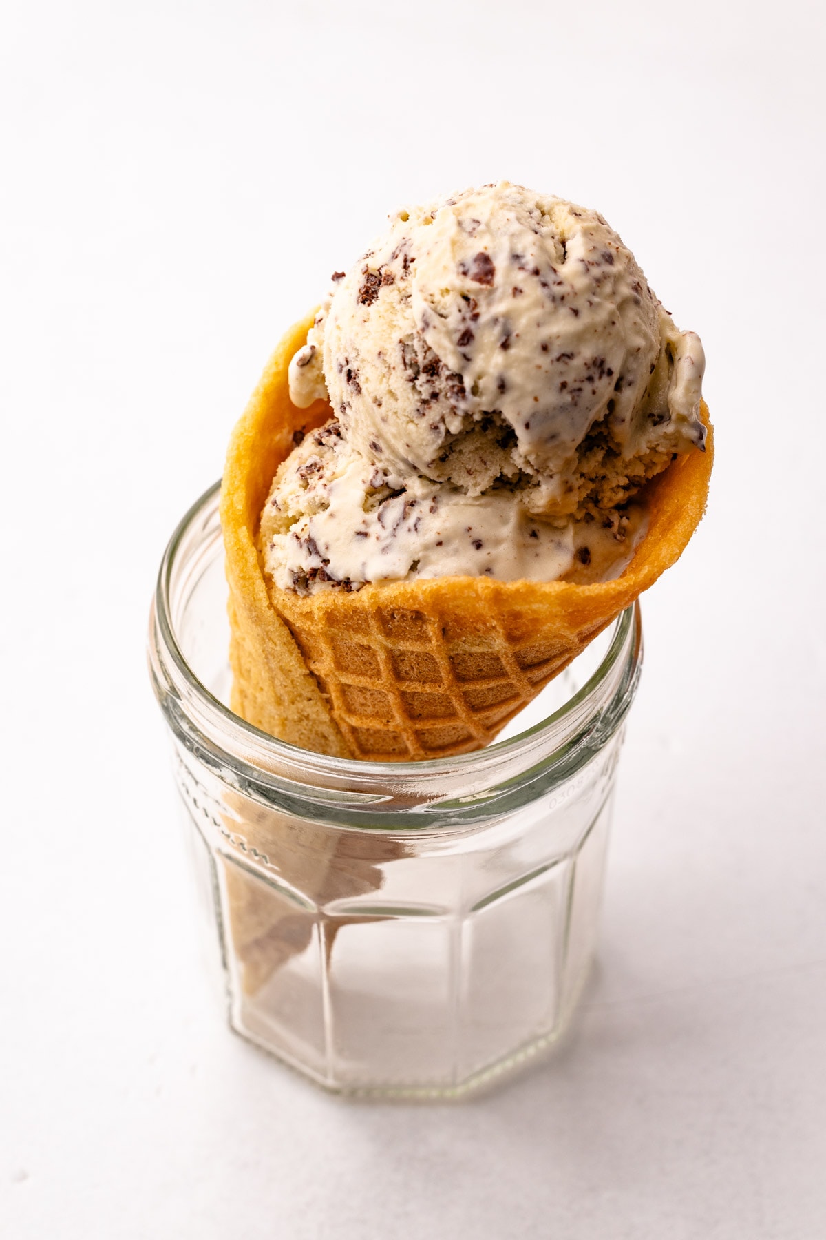 A scoop of ice cream in a homemade waffle cone.