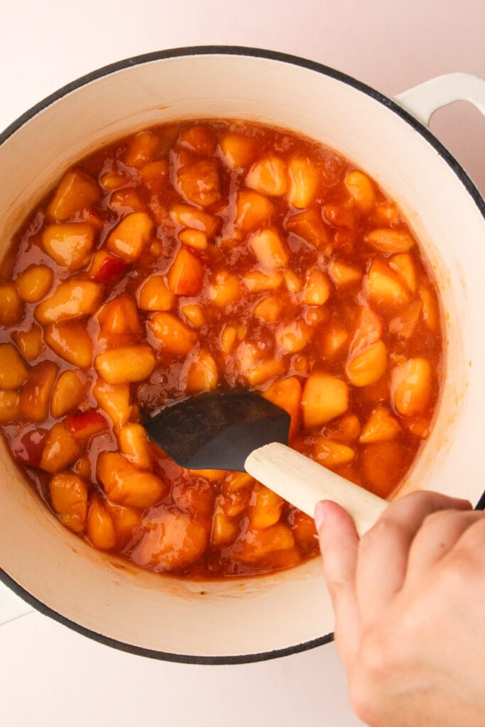 Cooking peach pie filling in a pot.