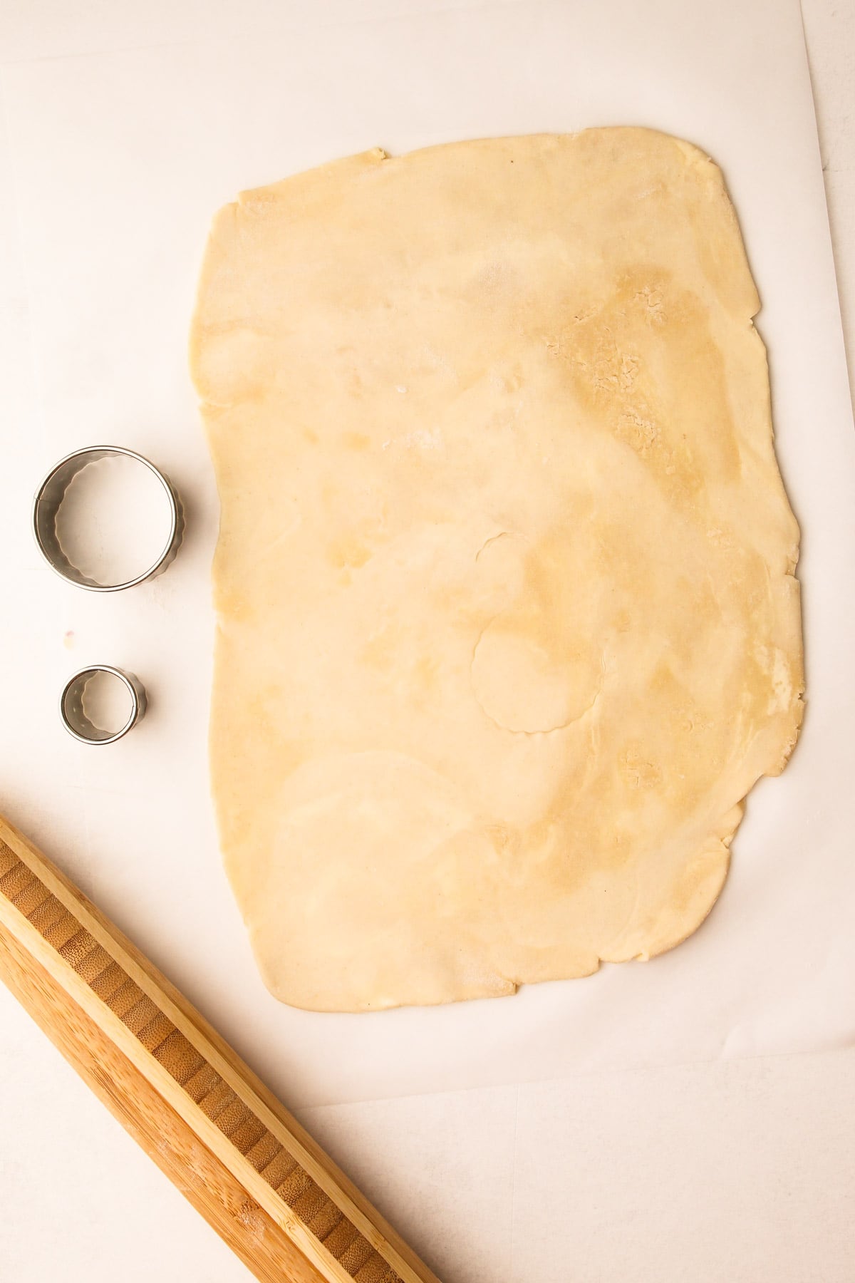 Rolled out pie crust with cookie cutters next to it.