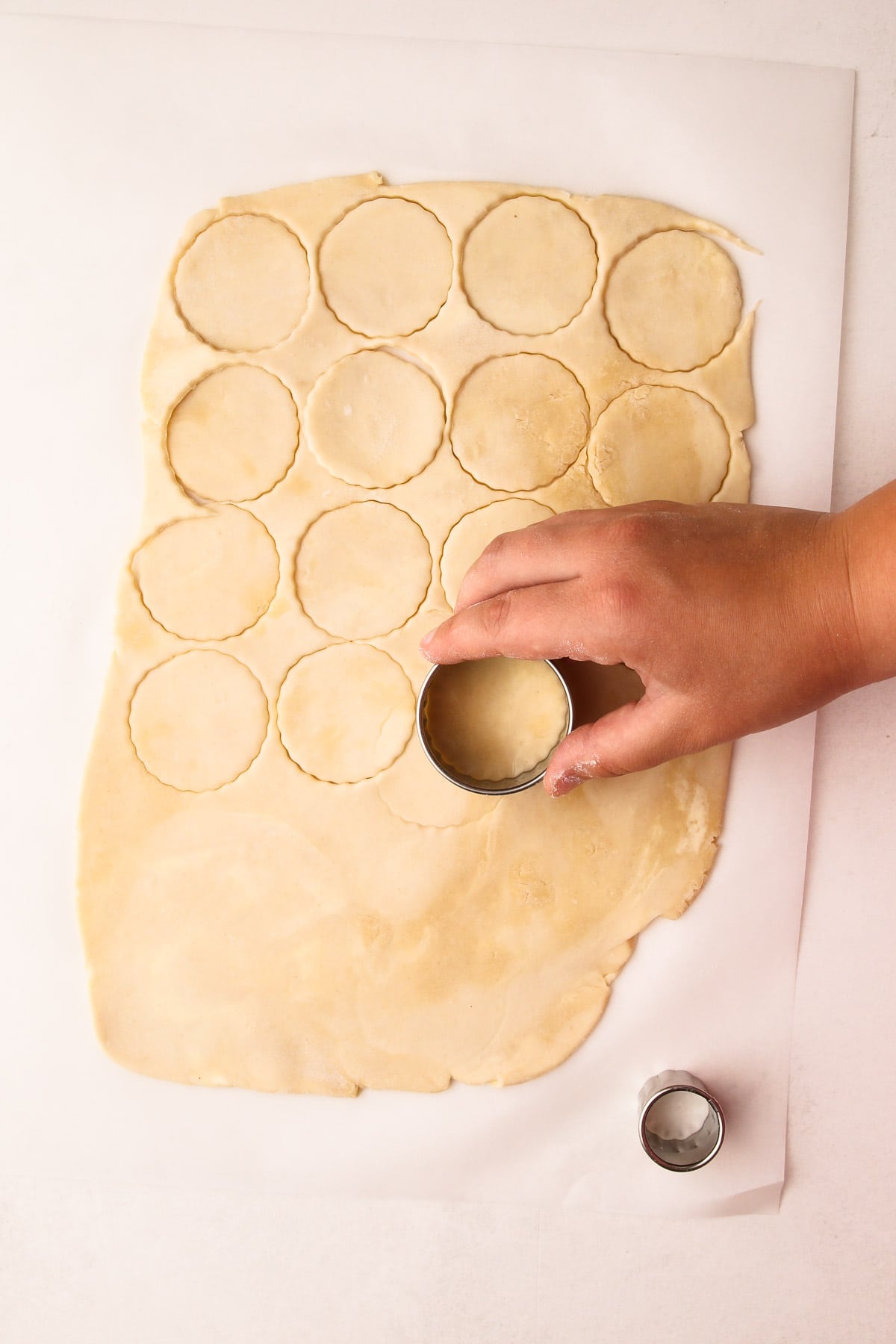 Cutting out cookies from pie crust with a cookie cutter.