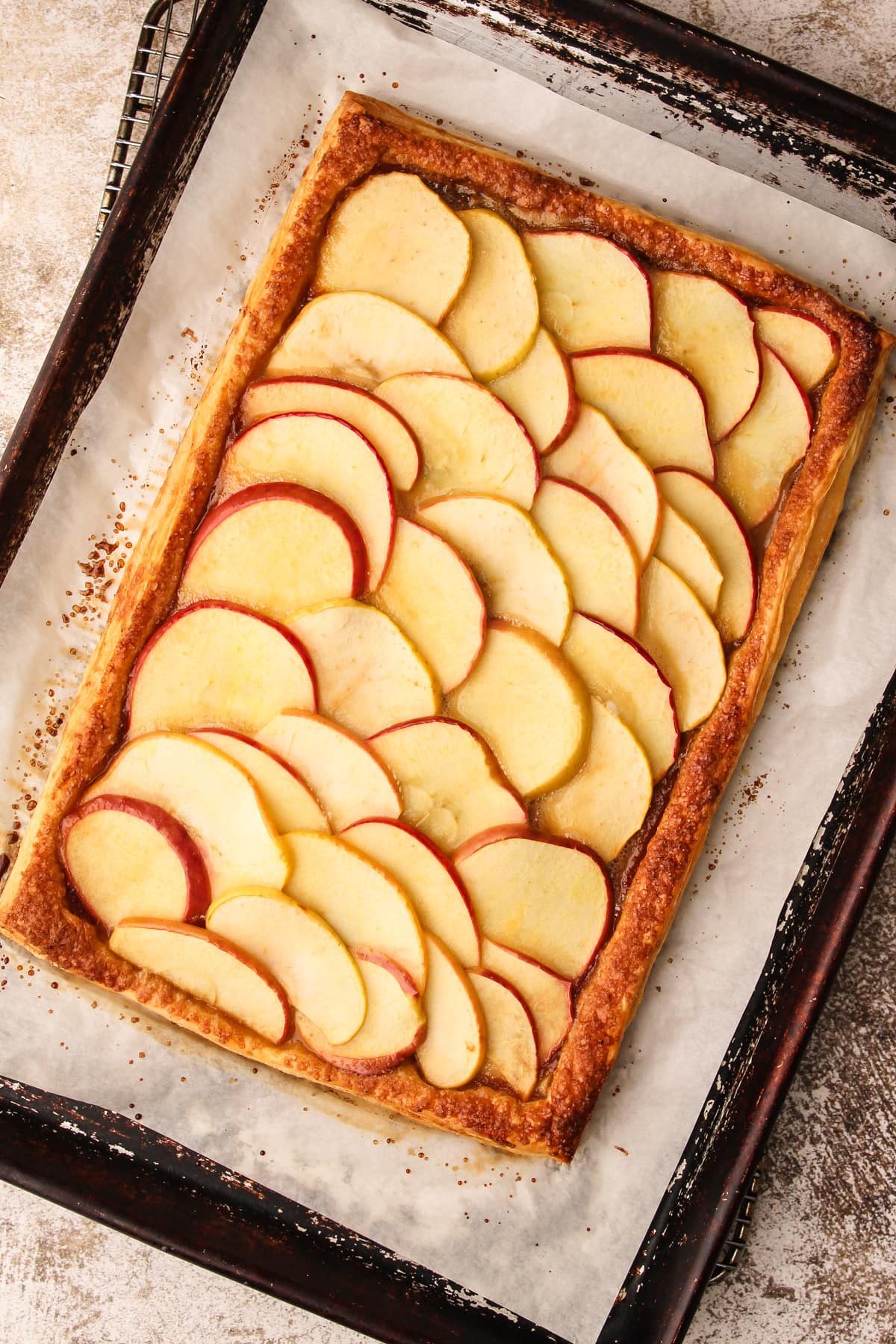 An baked apple tart on puff pastry.