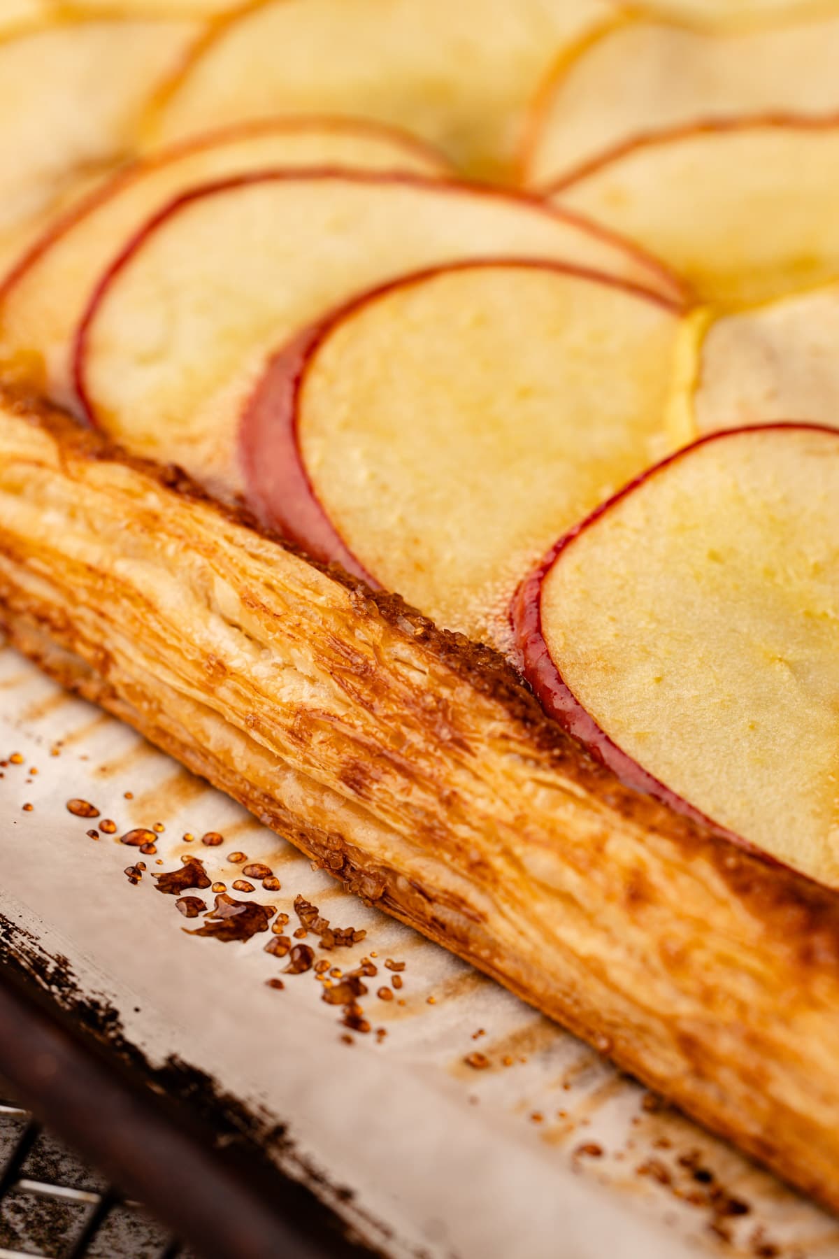 A close up of the puff pastry edge on the apple tart revealing layers.