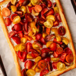 Tomato tart made with puff pastry baked on a sheet pan.