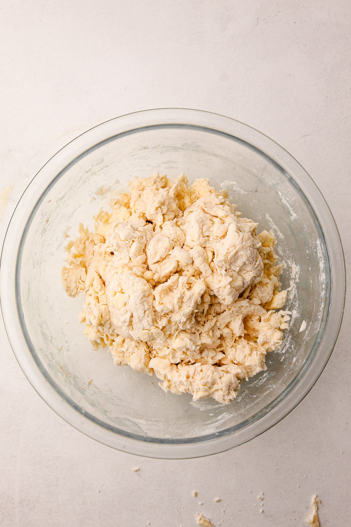 A glass bowl with a blended mixture of butter and flour in it