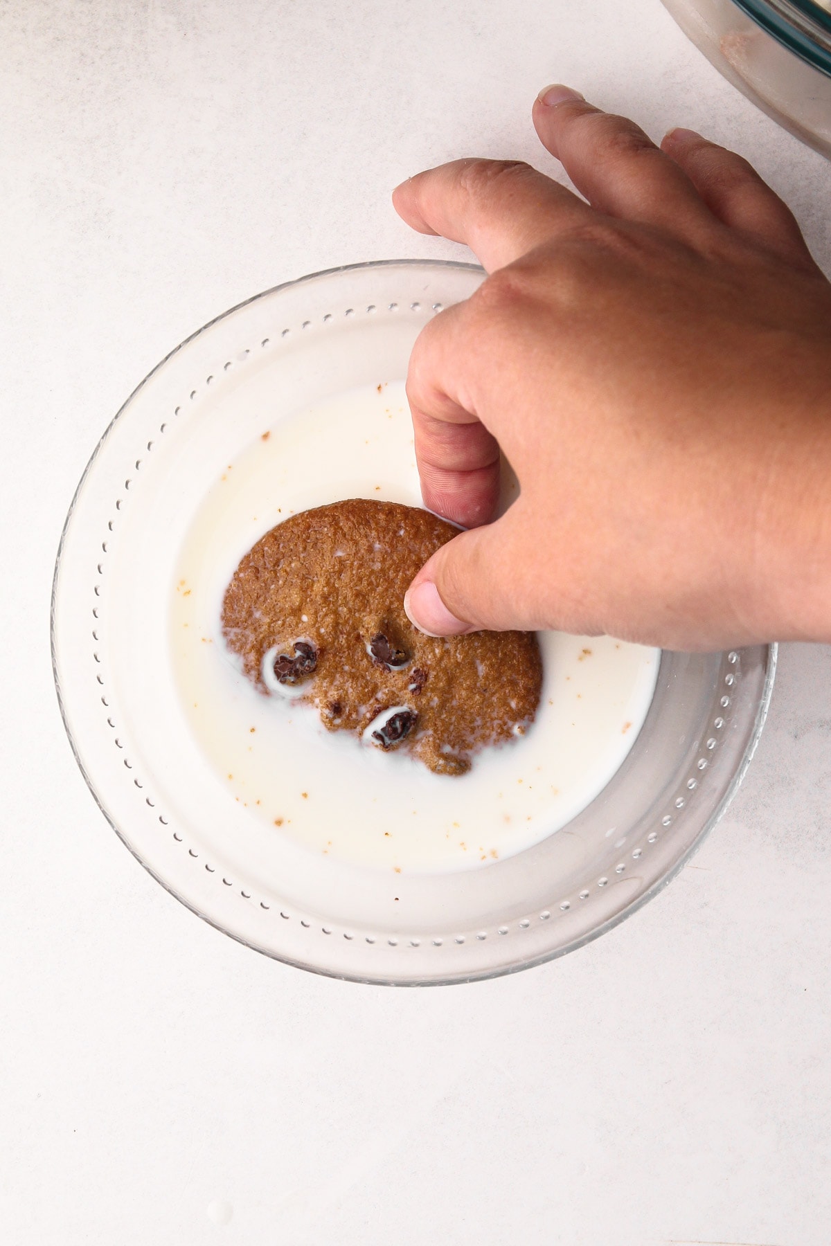 Dunking a chocolate chip cookie in milk.