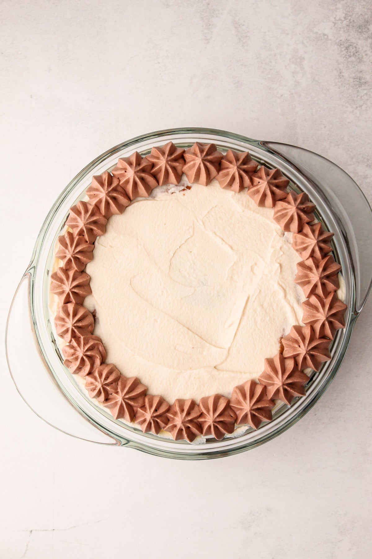 Chocolate whipped cream piped around the edge of the cookie icebox cake.