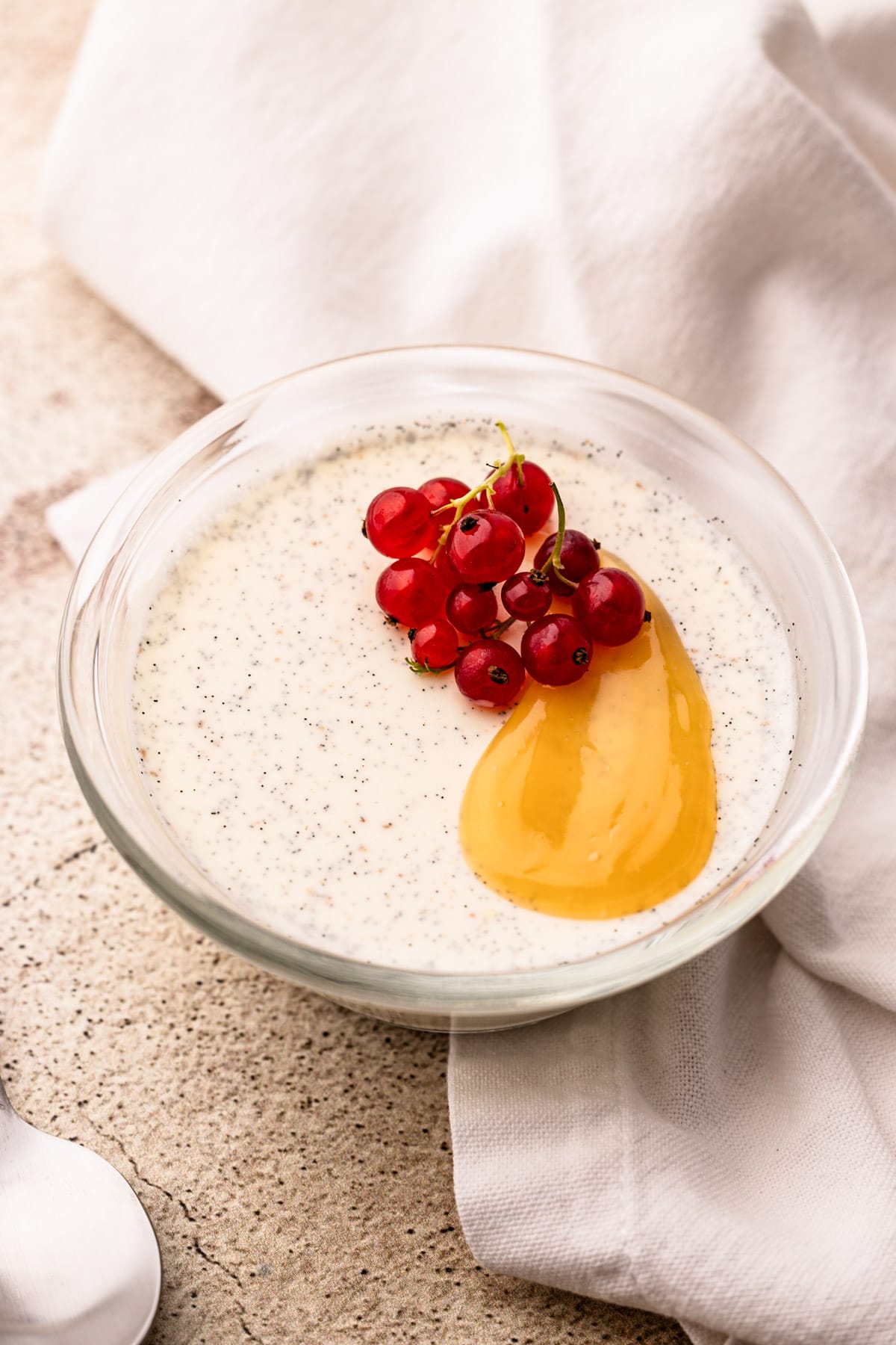 A bowl with panna cotta garnished with curd and berries.