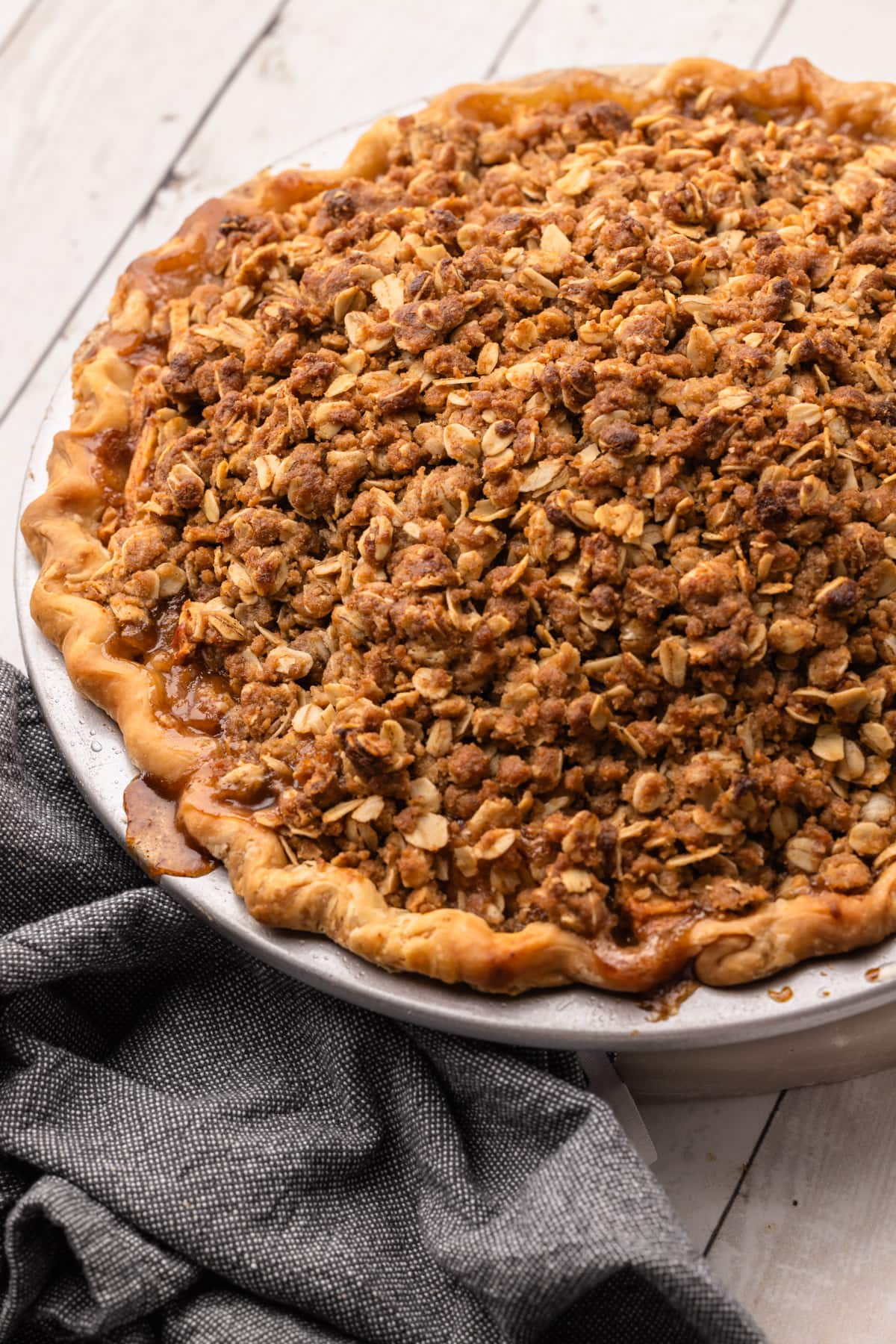 A fully baked apple crumb pie with an oat struesel topping.