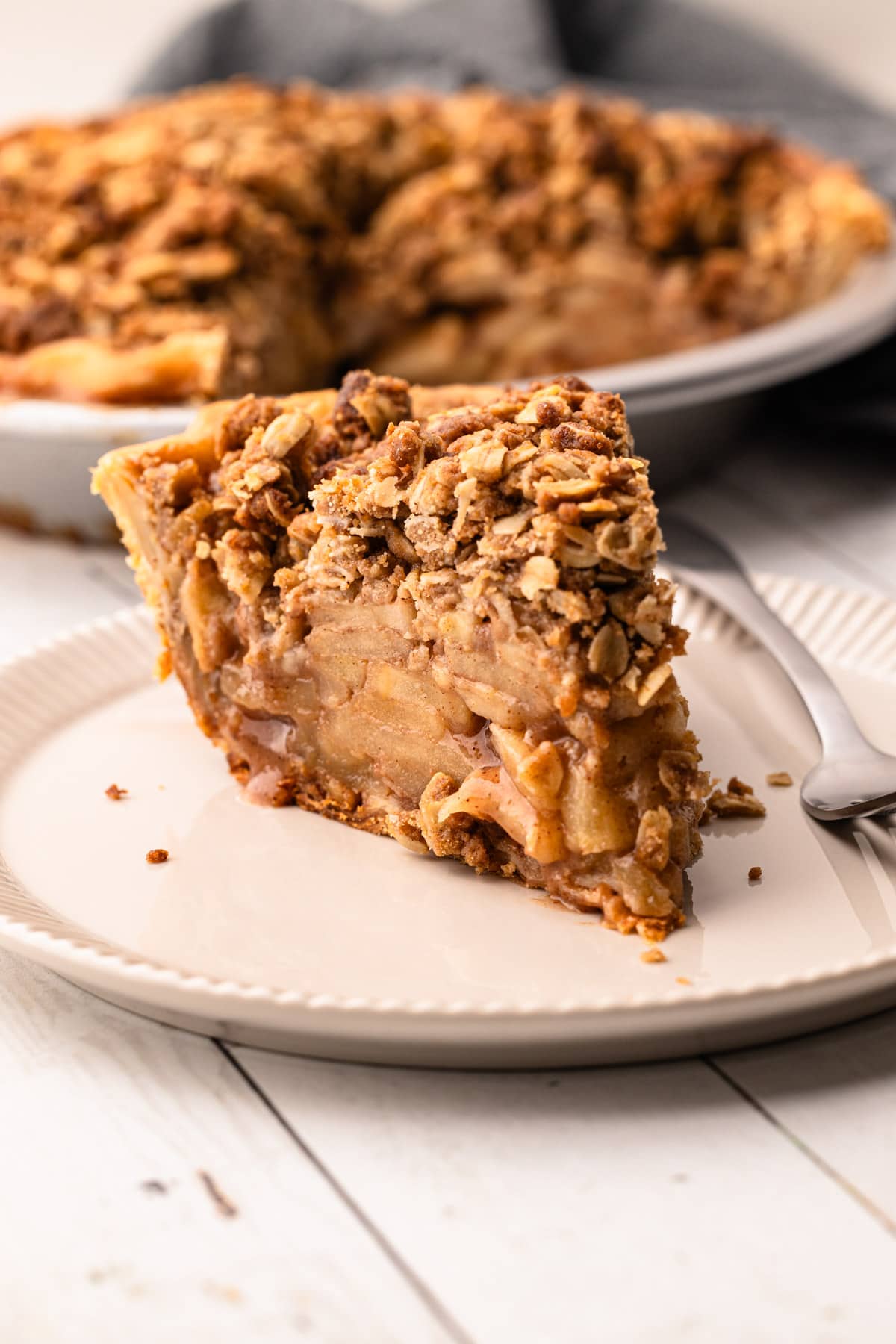 A slice of apple cumb pie on a plate.