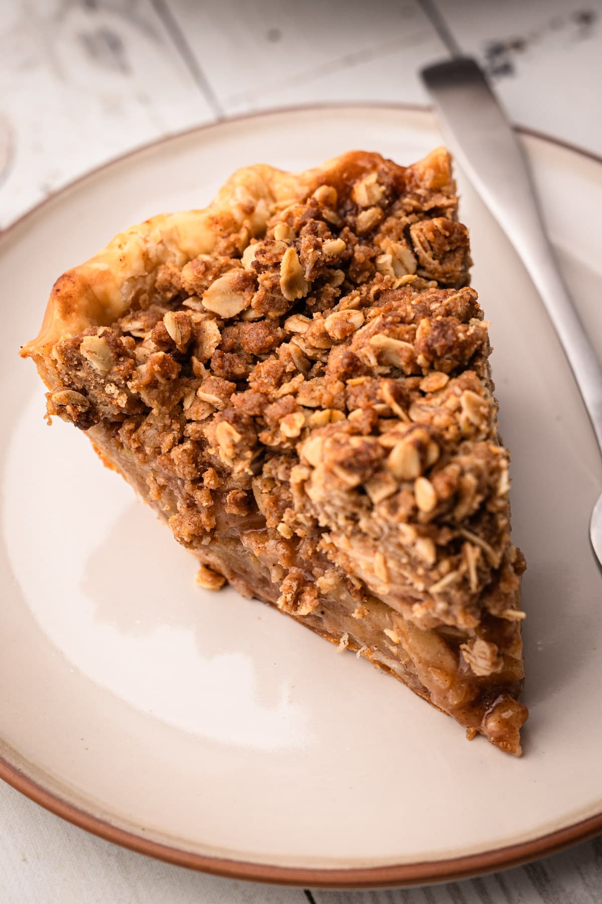 A slice of apple crumb pie on a plate.