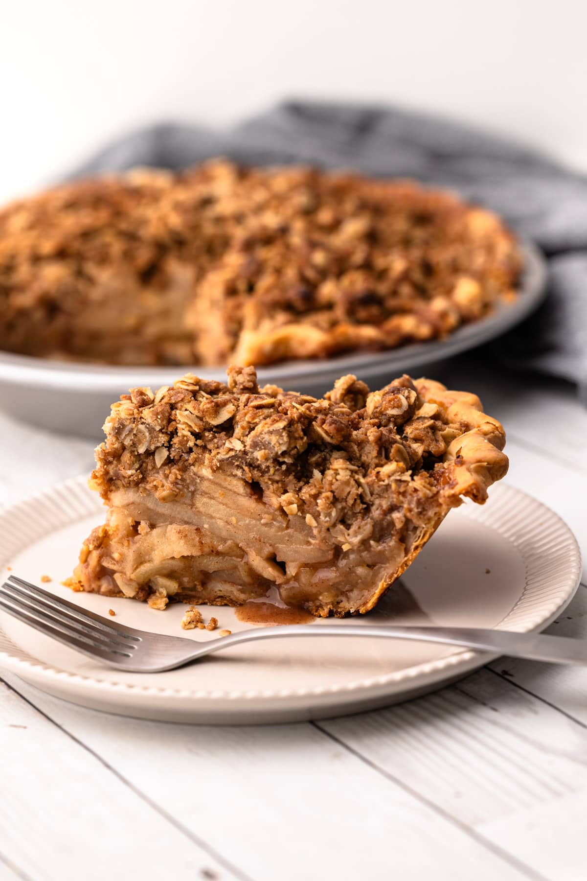 A slice of apple crumb pie on a plate.