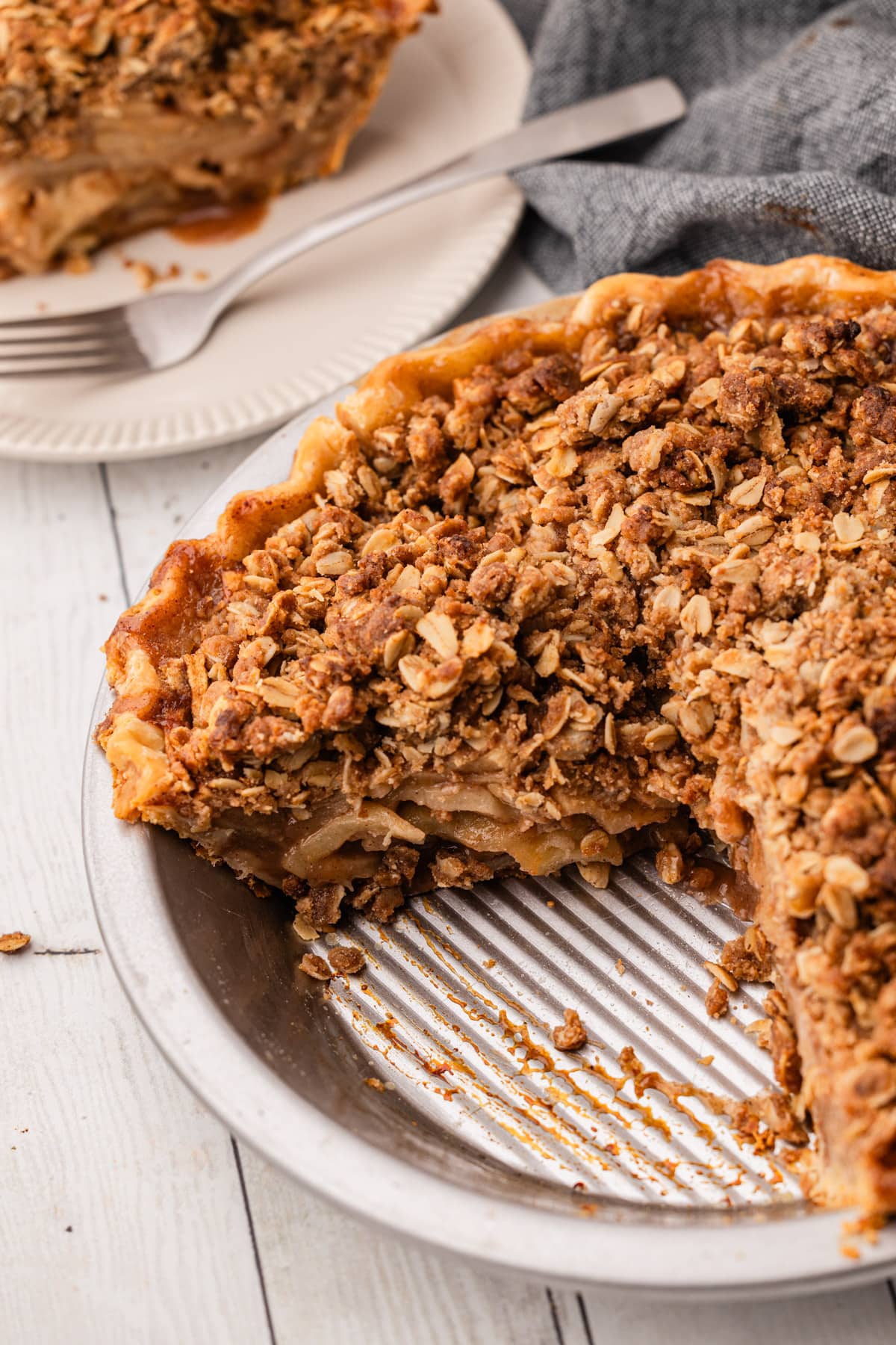 A baked apple crumb pie in a metal pie tin.