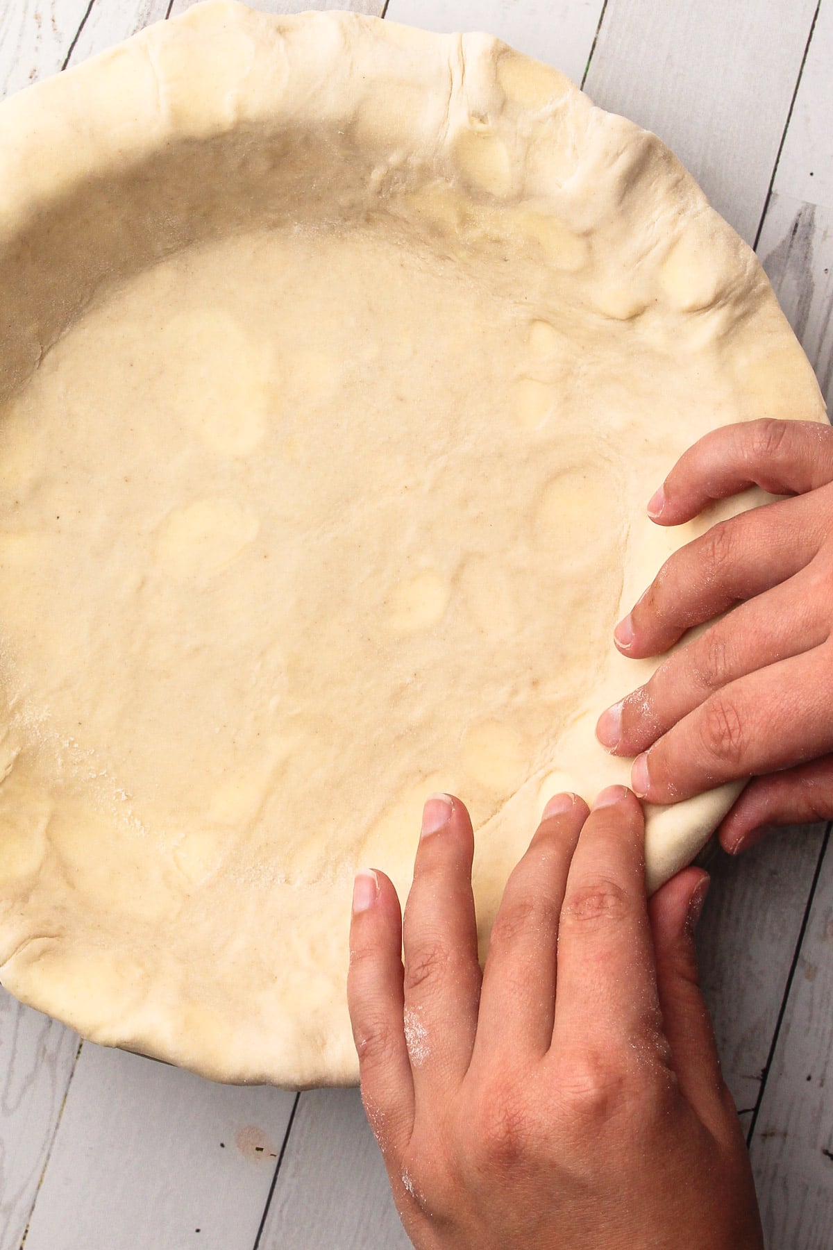 Placing pie crust in a pie tin.