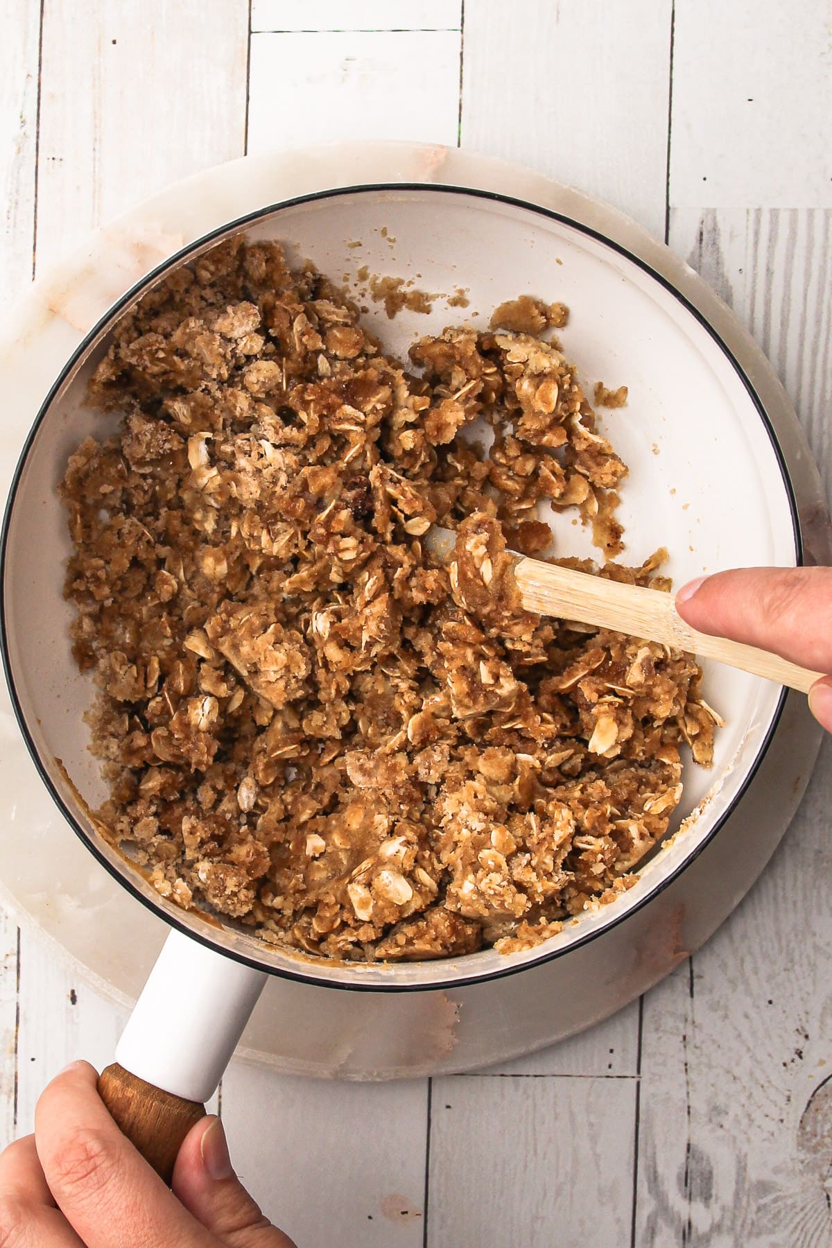 Uncooked streusel in a white pot for apple pie.