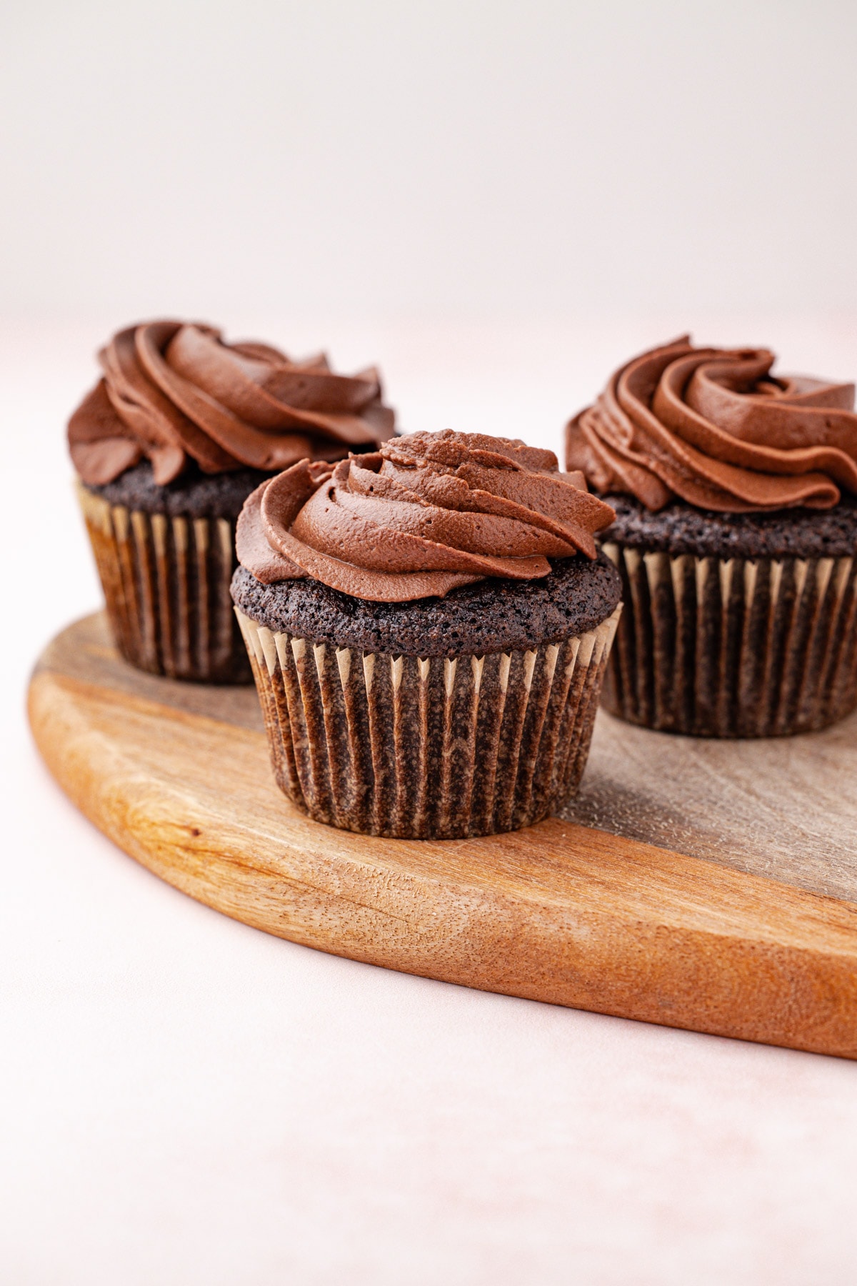 Whipped chocolate ganache frosting piped onto chocolate cupcakes.