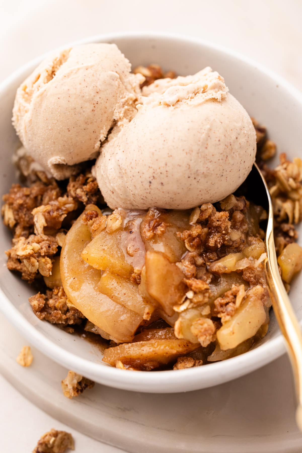 A bowl of baked apple crisp made from wholesome ingredients topped with ice cream.