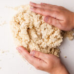 Hands bringing together pie dough.