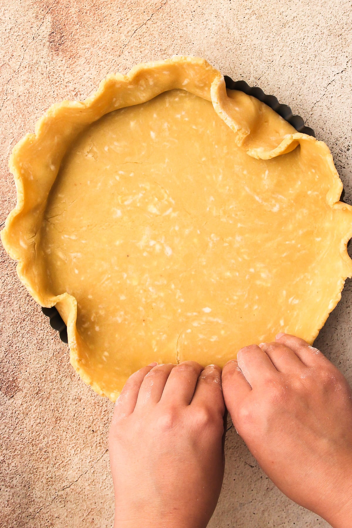 Shaping pastry into a tart pan.