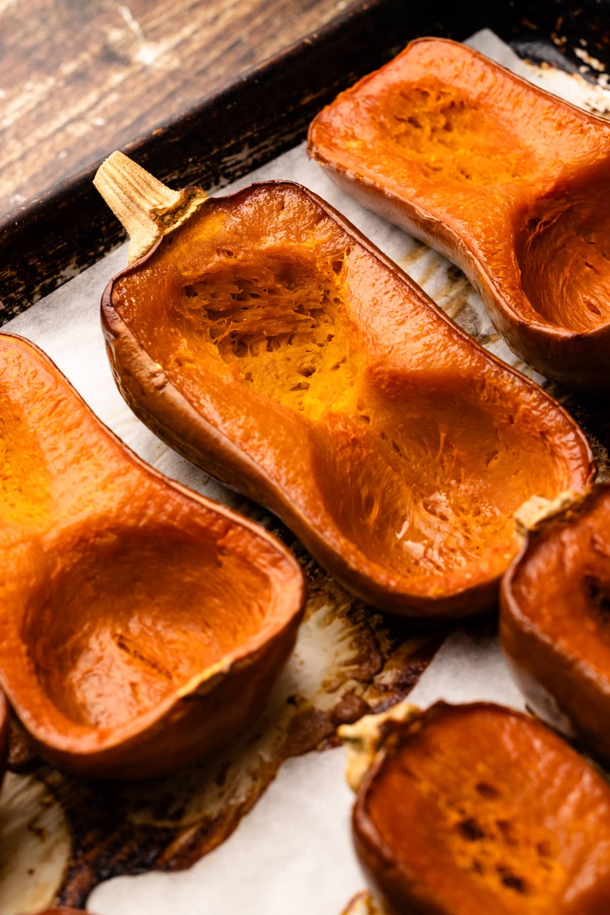 Roasted honeynut squash on a baking pan.