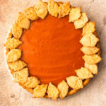 A baked Honeynut Squash Tart, decorated with leaf and acorn crust cutouts around the edge.