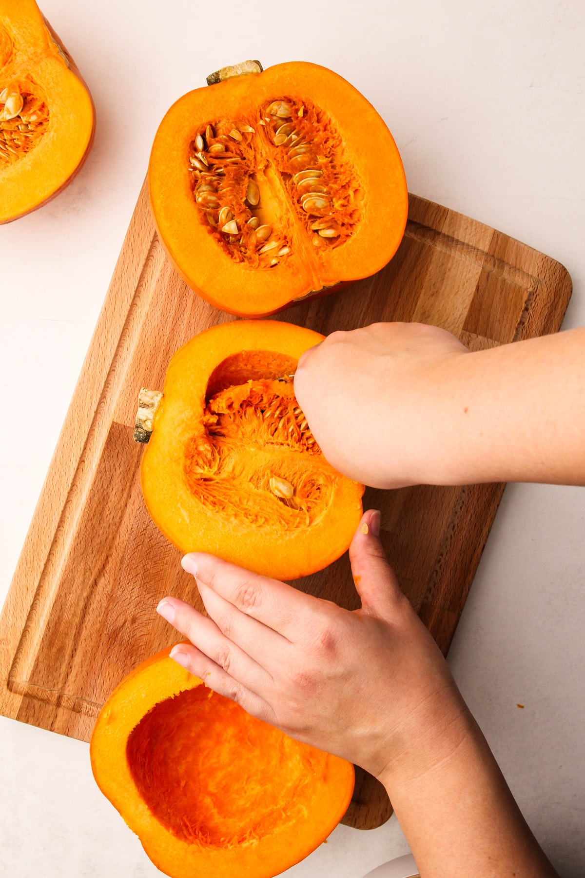 Scooping out the seeds from a sugar pumpkin.