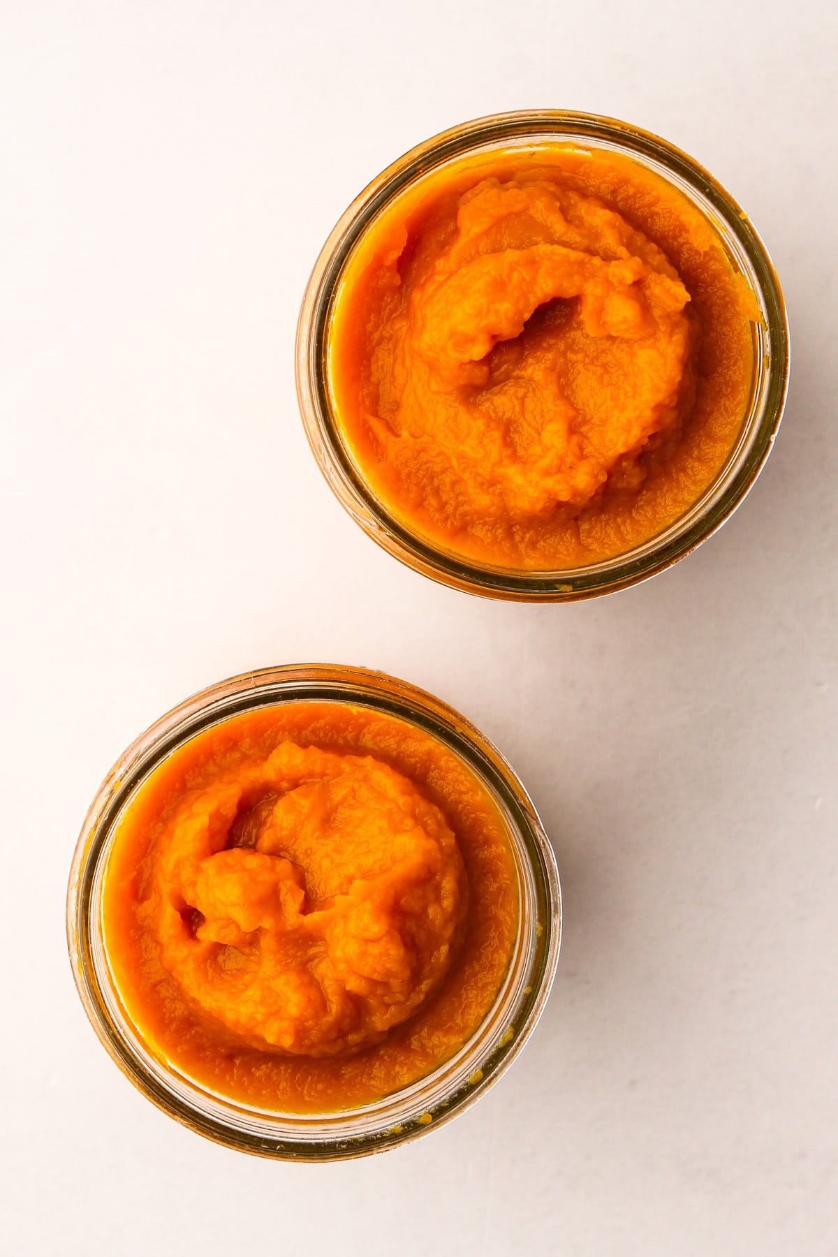 Homemade pumpkin puree in two mason jars.