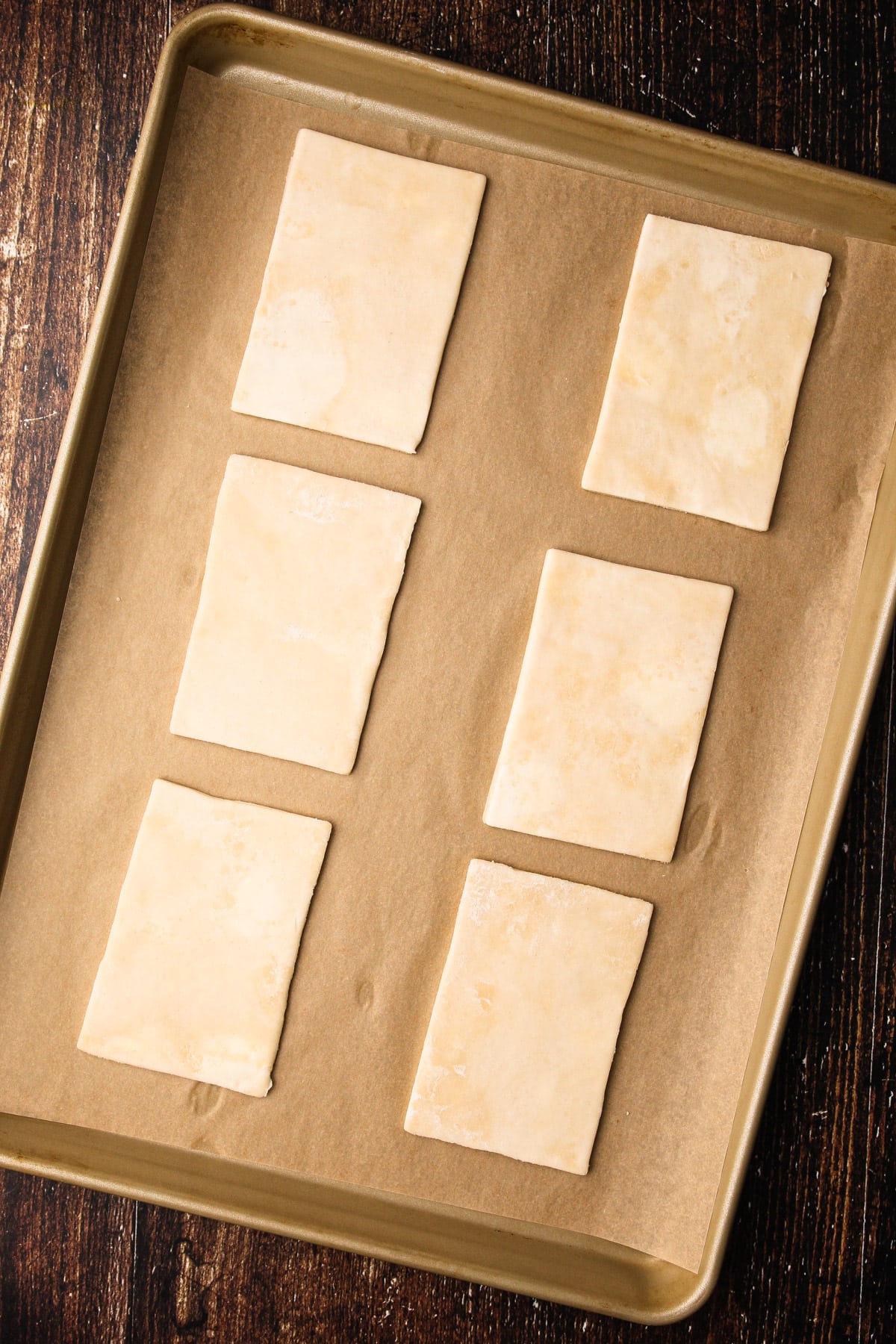 Butter pie dough rolled and cut into rectangles and laid out on a sheet pan.