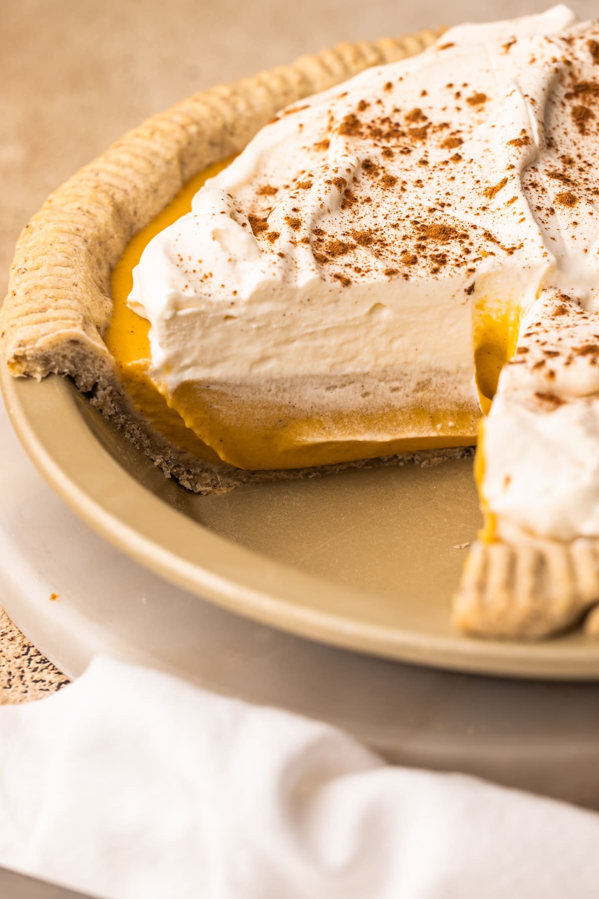 A Pumpkin Cream Pie in with a slice taken out of it.