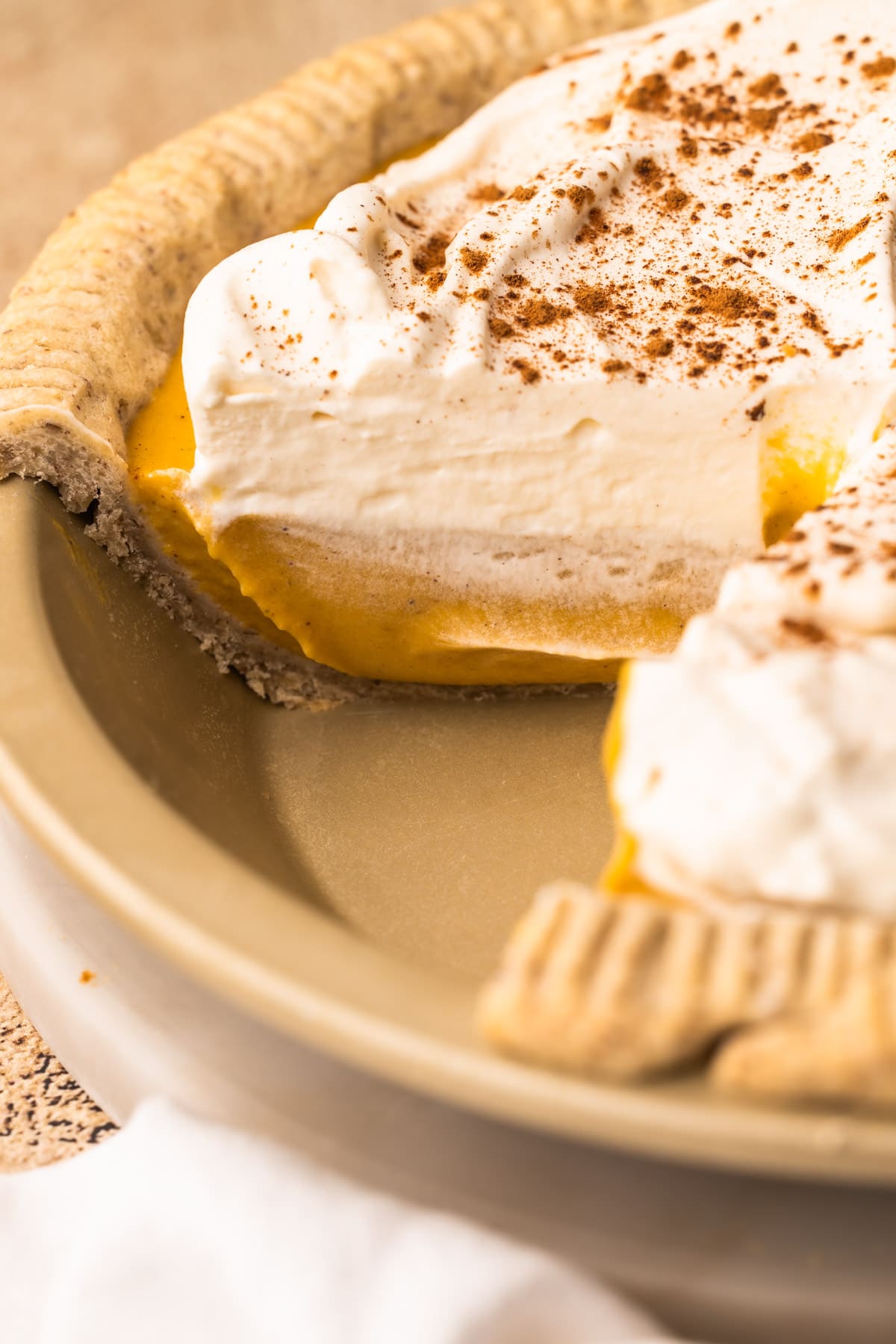 A Pumpkin Cream Pie in with a slice taken out of it.