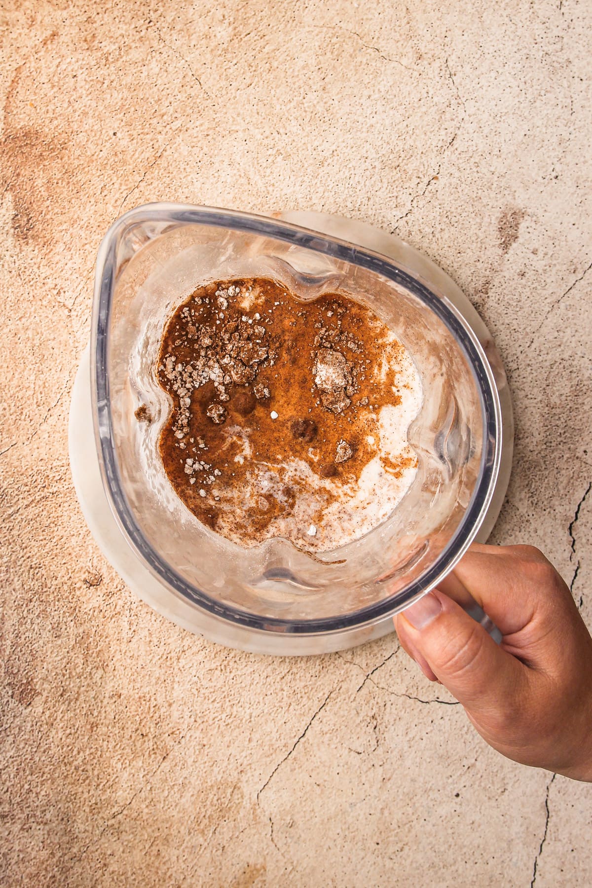 A blender jar with filling ingredients in it for Pumpkin Cream Pie.