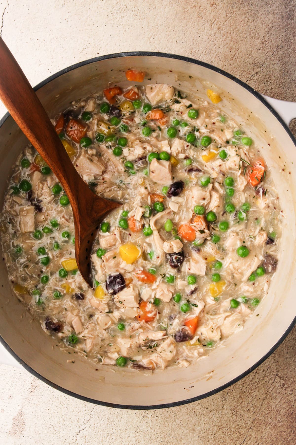 Turkey pot pie filling in a white dutch oven.