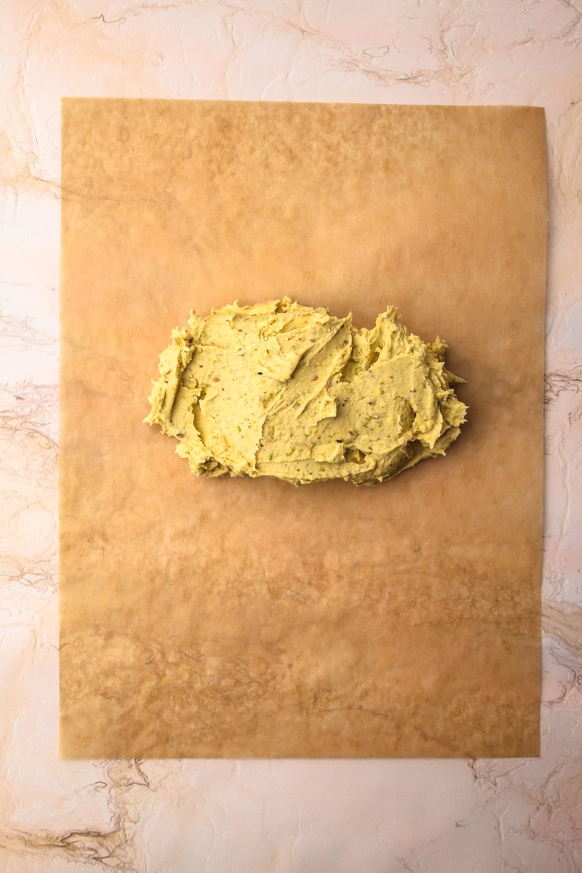 Pistachio shortbread cookie dough on a piece of parchment paper.